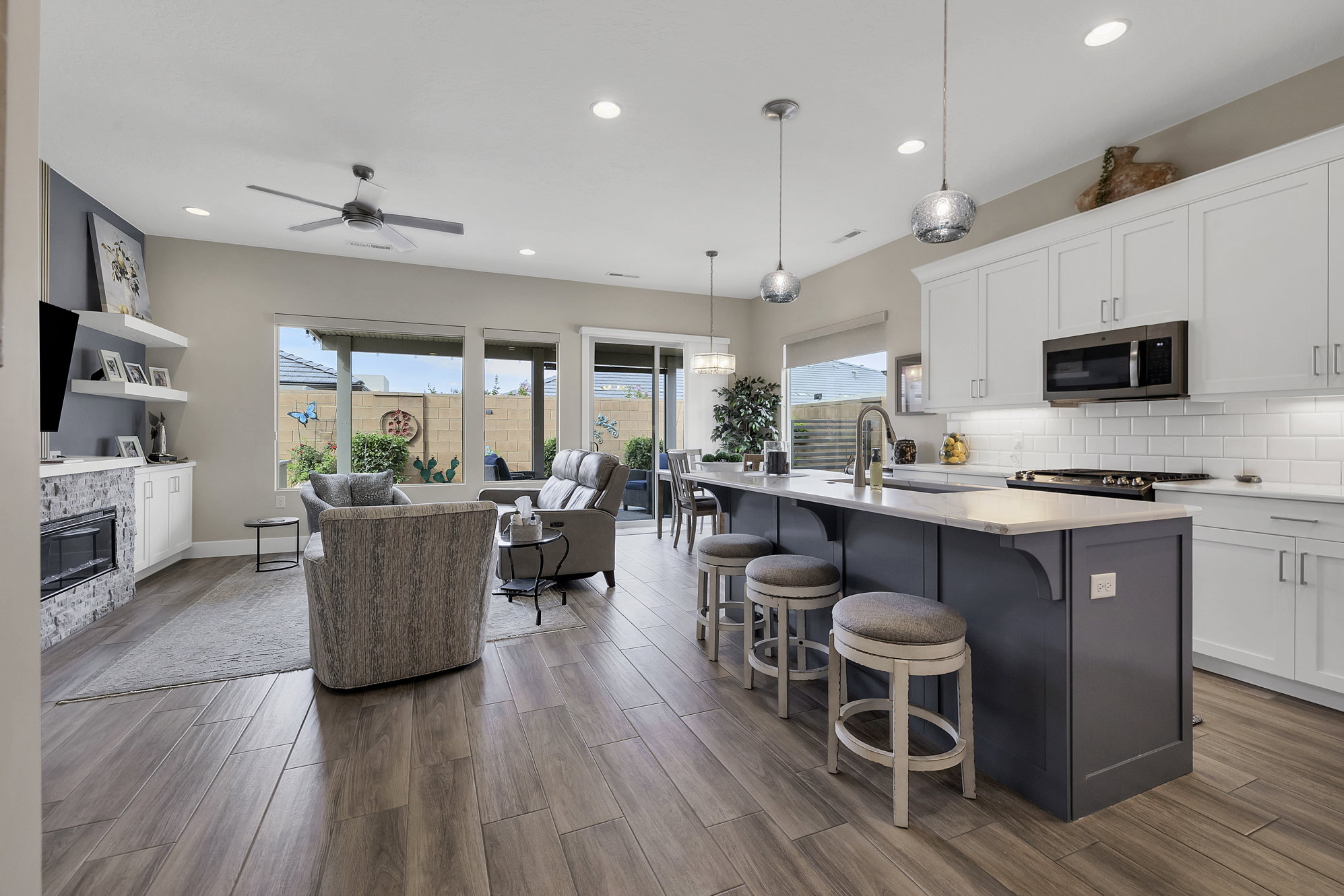 Open-concept living space featuring wood-finish flooring, a contemporary ceiling fan, and recessed lighting