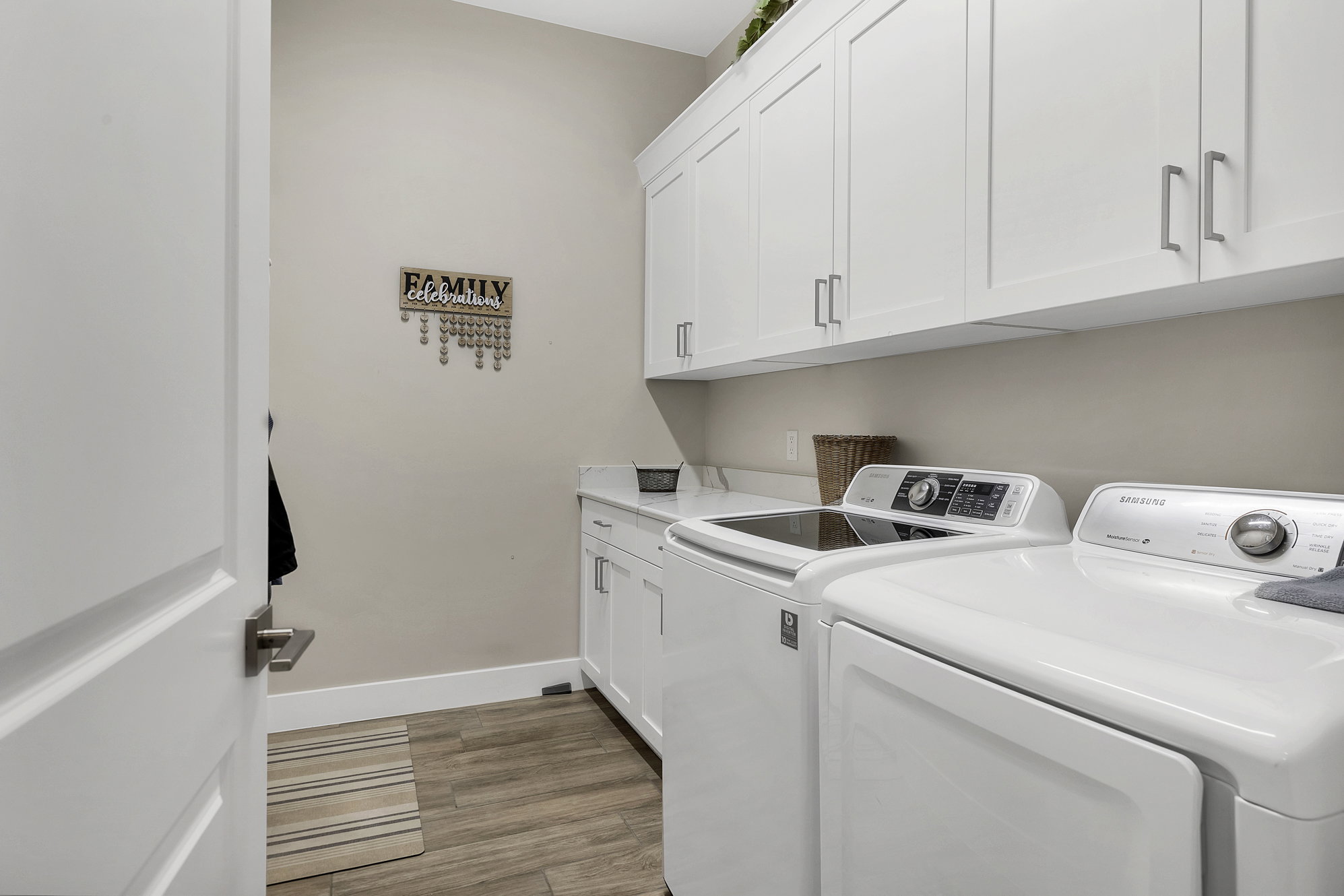 Dedicated laundry area featuring wood-finish flooring