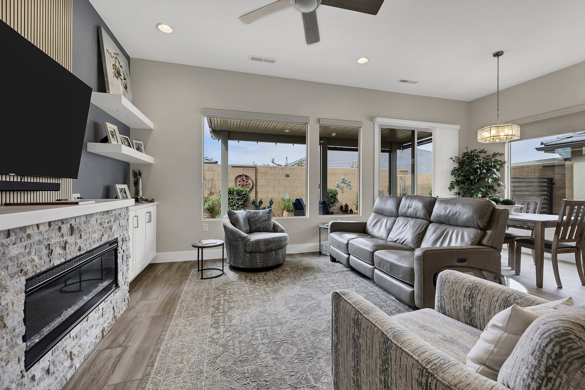 Living area featuring a floor-to-ceiling accent wall with vertical wood paneling and a linear electric fireplace with stone surround