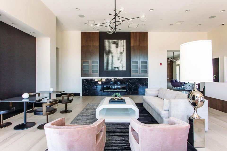 Spacious common area featuring a modern fireplace with black stone surround, dark wood cabinetry, and recessed lighting