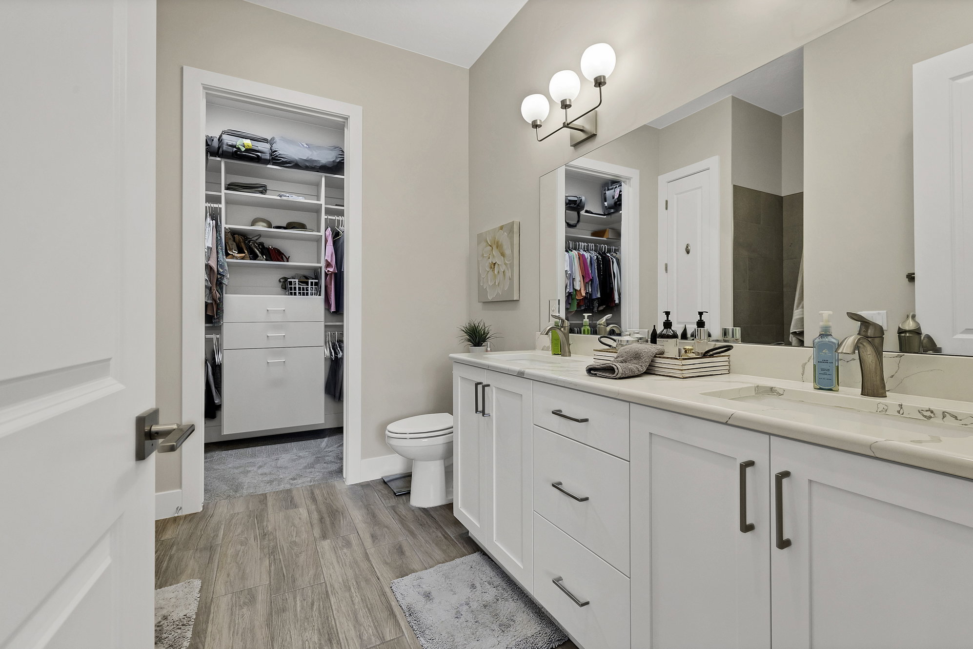 Bathroom featuring a dual vanity with white cabinetry, light-toned countertops, and integrated sinks