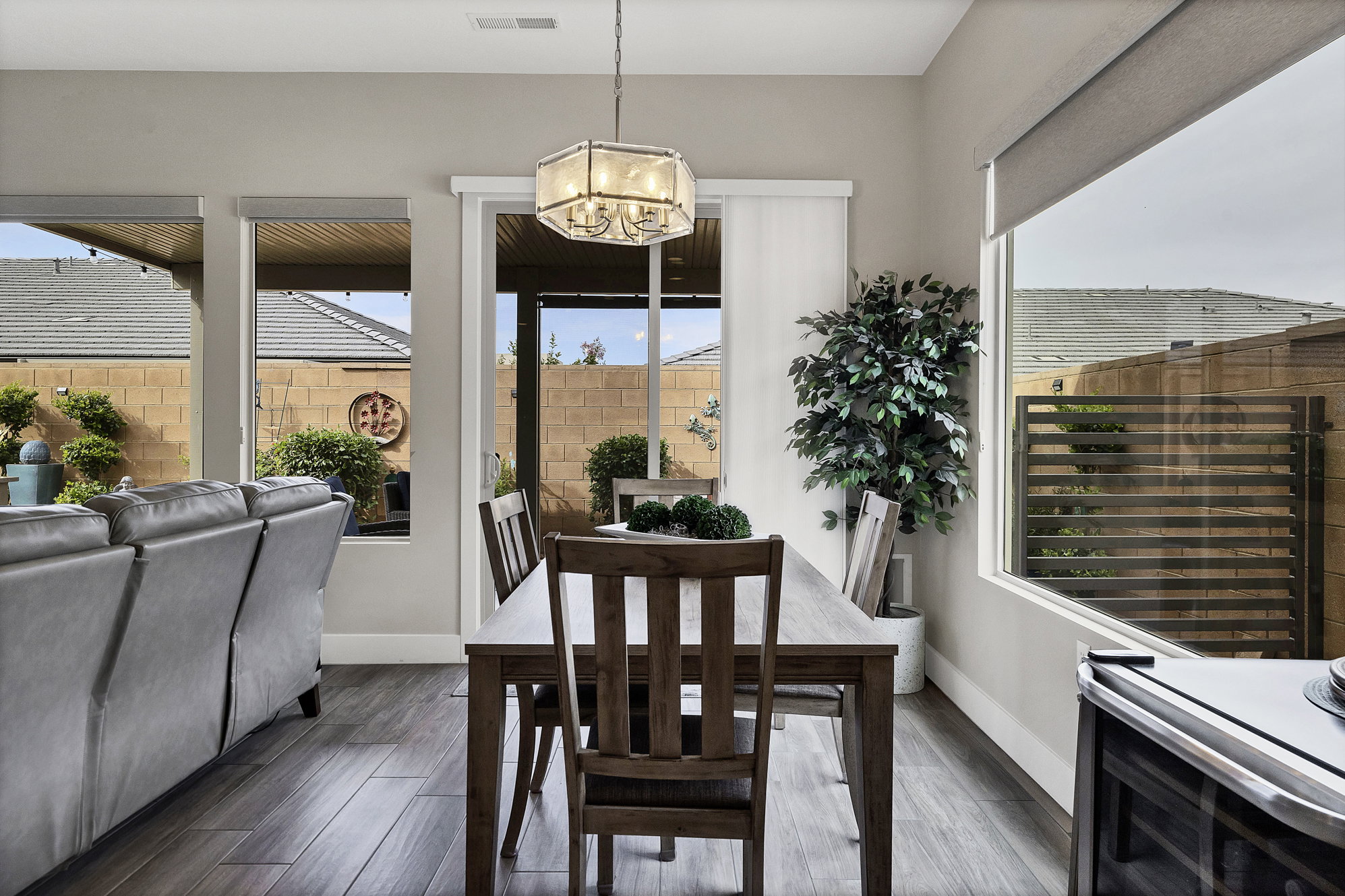 Dining area featuring wood-finish flooring, a contemporary chandelier, and a sliding glass door providing access to the outdoors