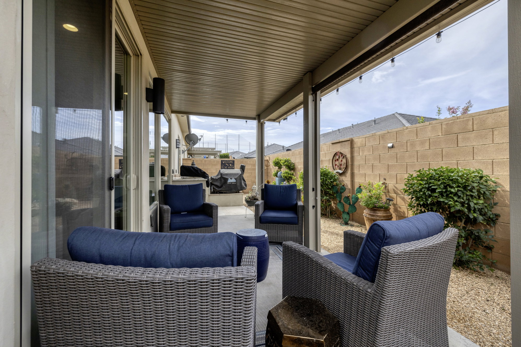 Covered patio with recessed lighting, exposed aggregate concrete flooring, and string lights