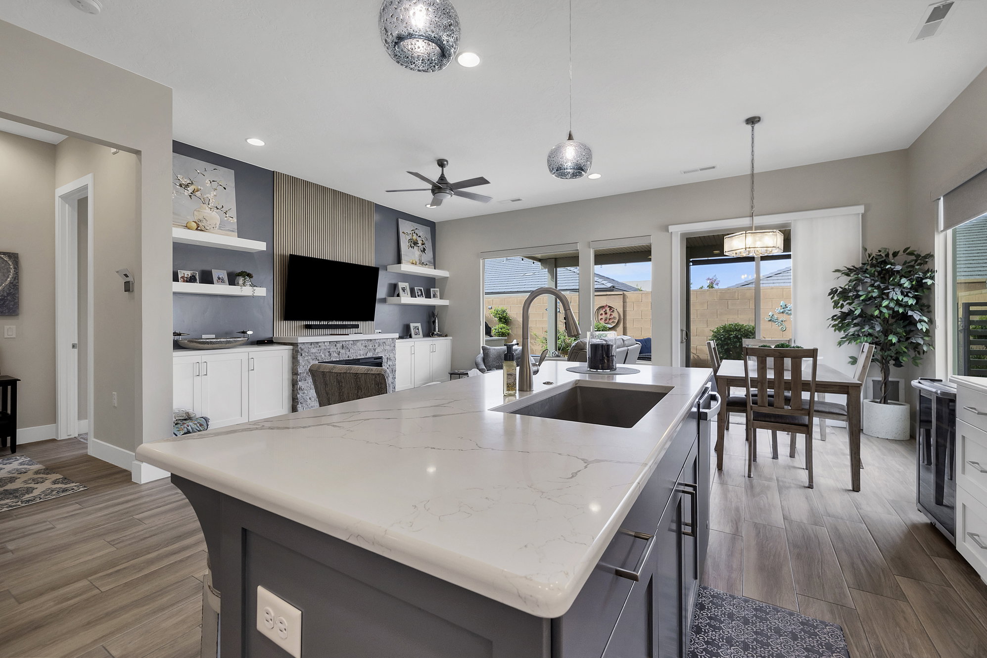 Kitchen island featuring a substantial countertop with an undermount sink and a gooseneck faucet