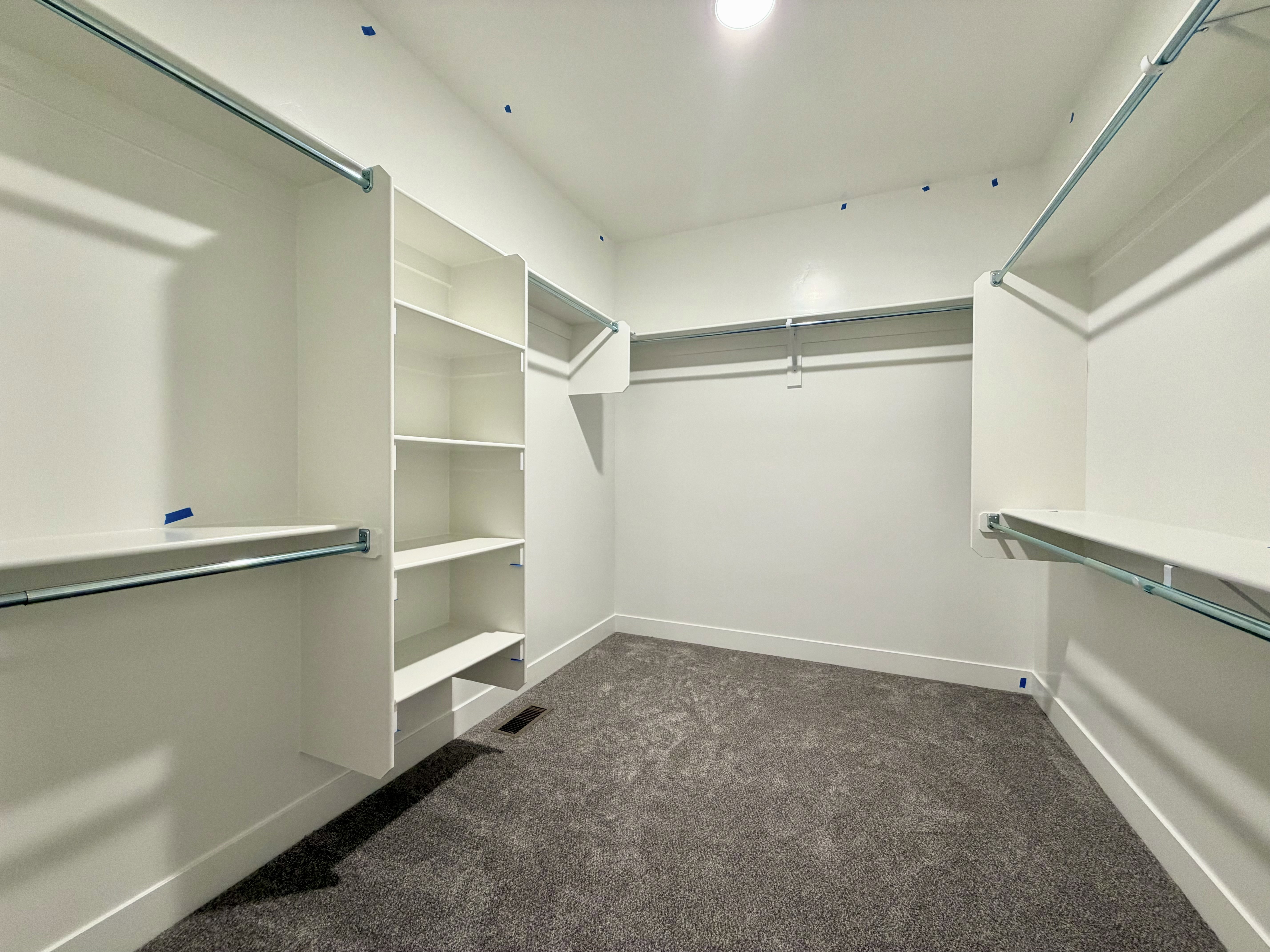 Walk-in closet featuring built-in shelving, hanging rods, recessed lighting, and carpet flooring