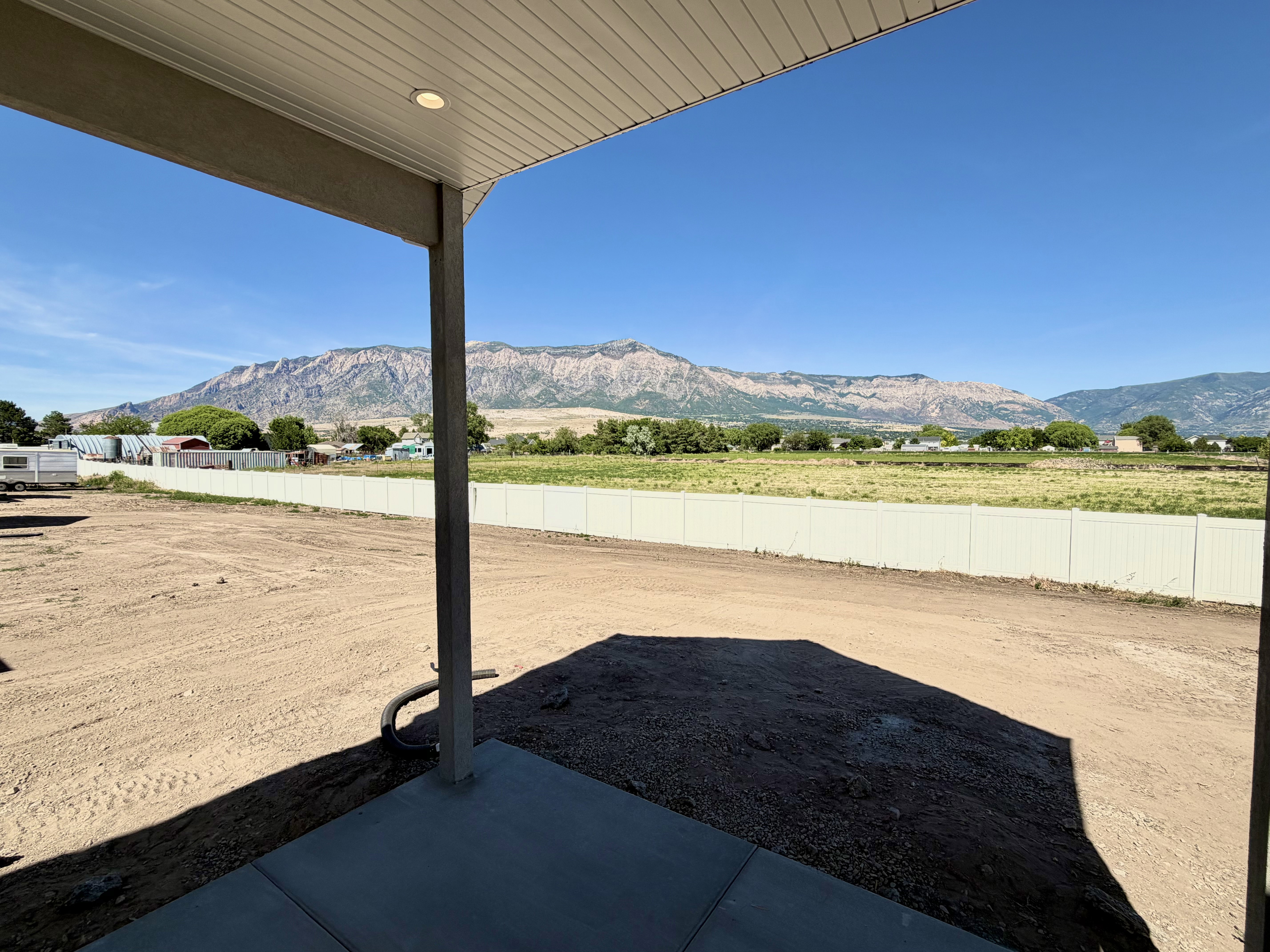 Covered patio with recessed lighting, concrete flooring, and distant mountain scenery