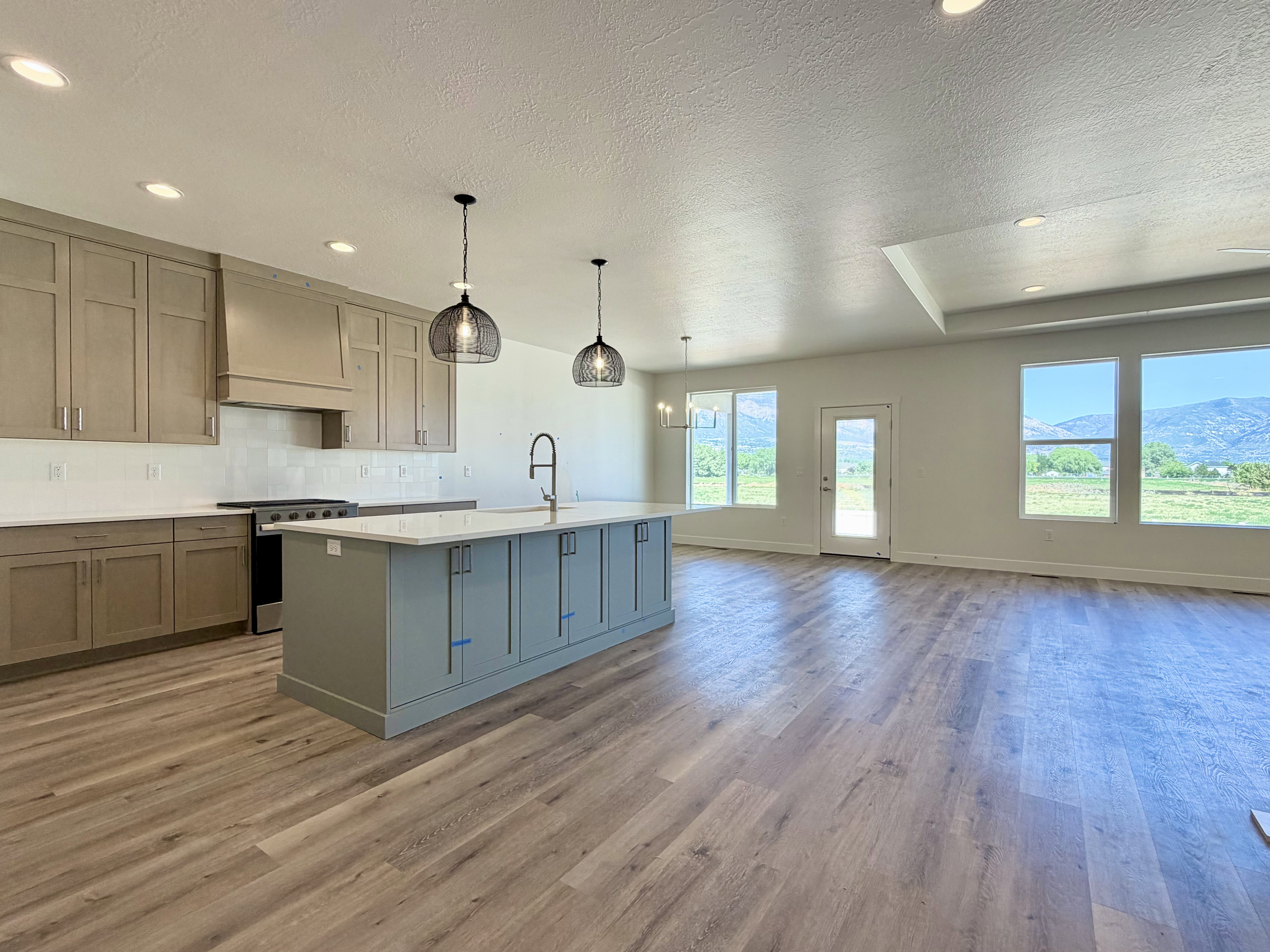Open-concept living area featuring a kitchen with light-toned cabinetry and an expansive island