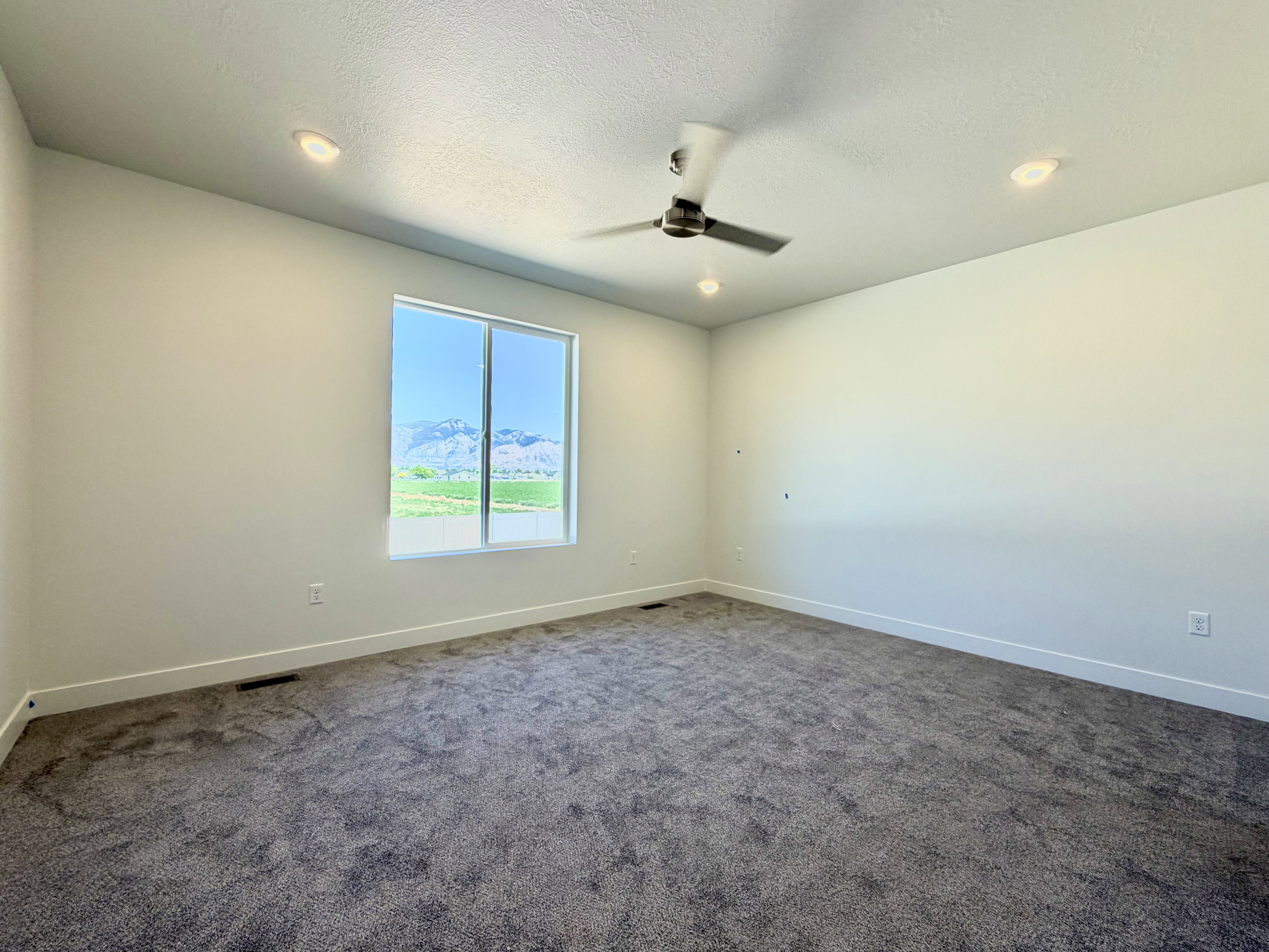 Bedroom with neutral-toned walls, recessed lighting, and a ceiling fan