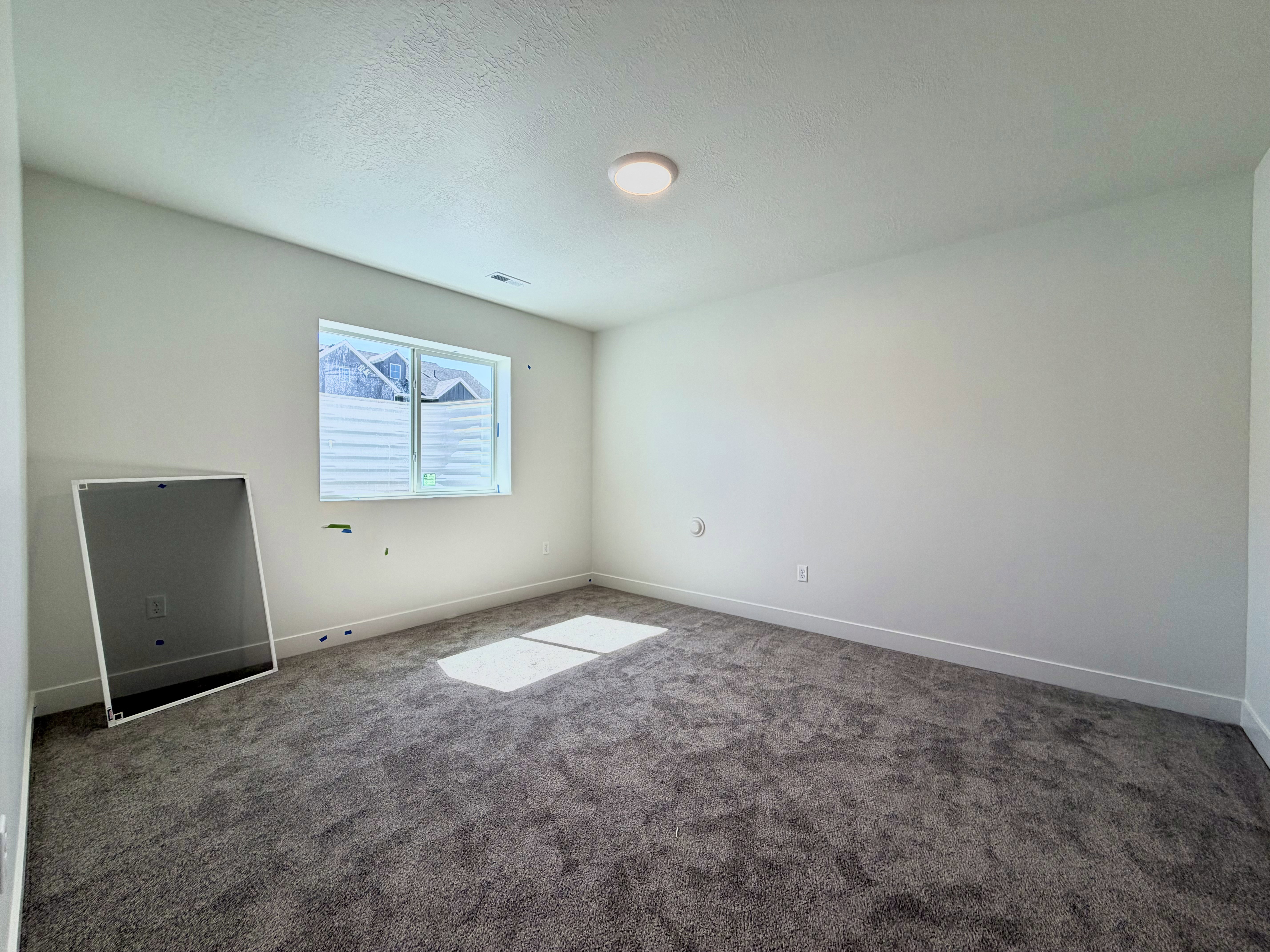 Carpeted interior space with a single window and recessed lighting