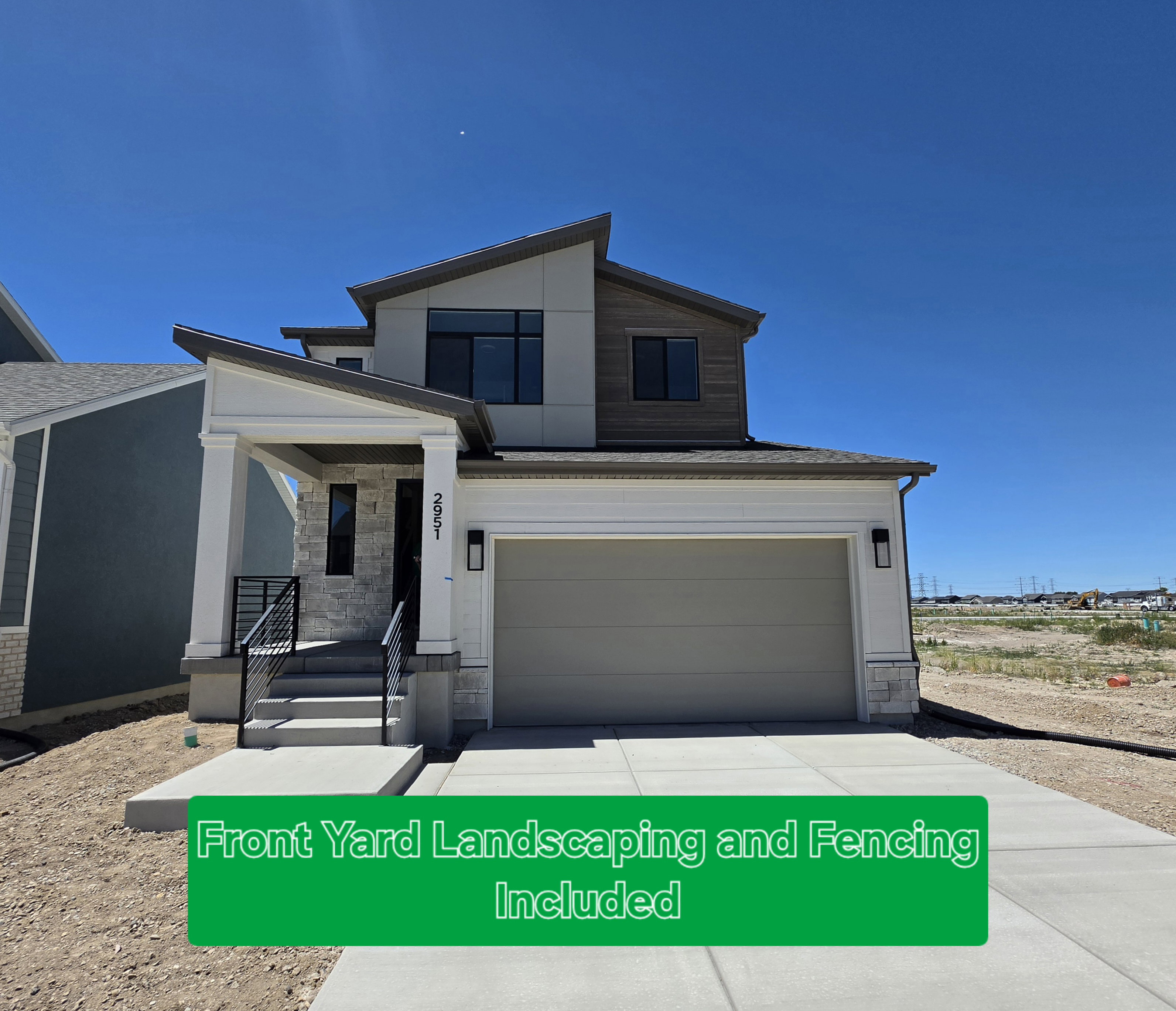 Contemporary exterior featuring a covered entry, stone accents, two-car garage, and modern metal railings