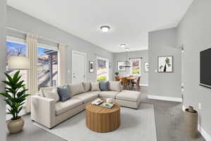 Open-concept living space featuring light gray walls, white trim, and recessed lighting