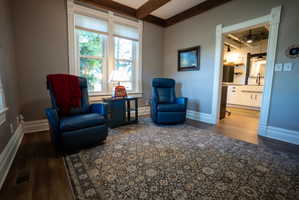 Interior space featuring wood-finish flooring, a decorative area rug, and detailed white trim work