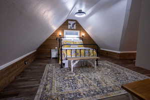 Room featuring sloped ceilings and wood-finish flooring