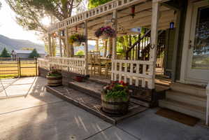 Expansive deck featuring white wood railings, a pergola roof, and direct access to concrete patio space