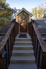 Exterior entrance featuring a wood-finish door with an arched glass panel