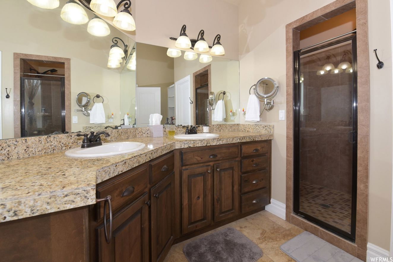 Dual undermount sinks set into a granite countertop with rich wood cabinetry