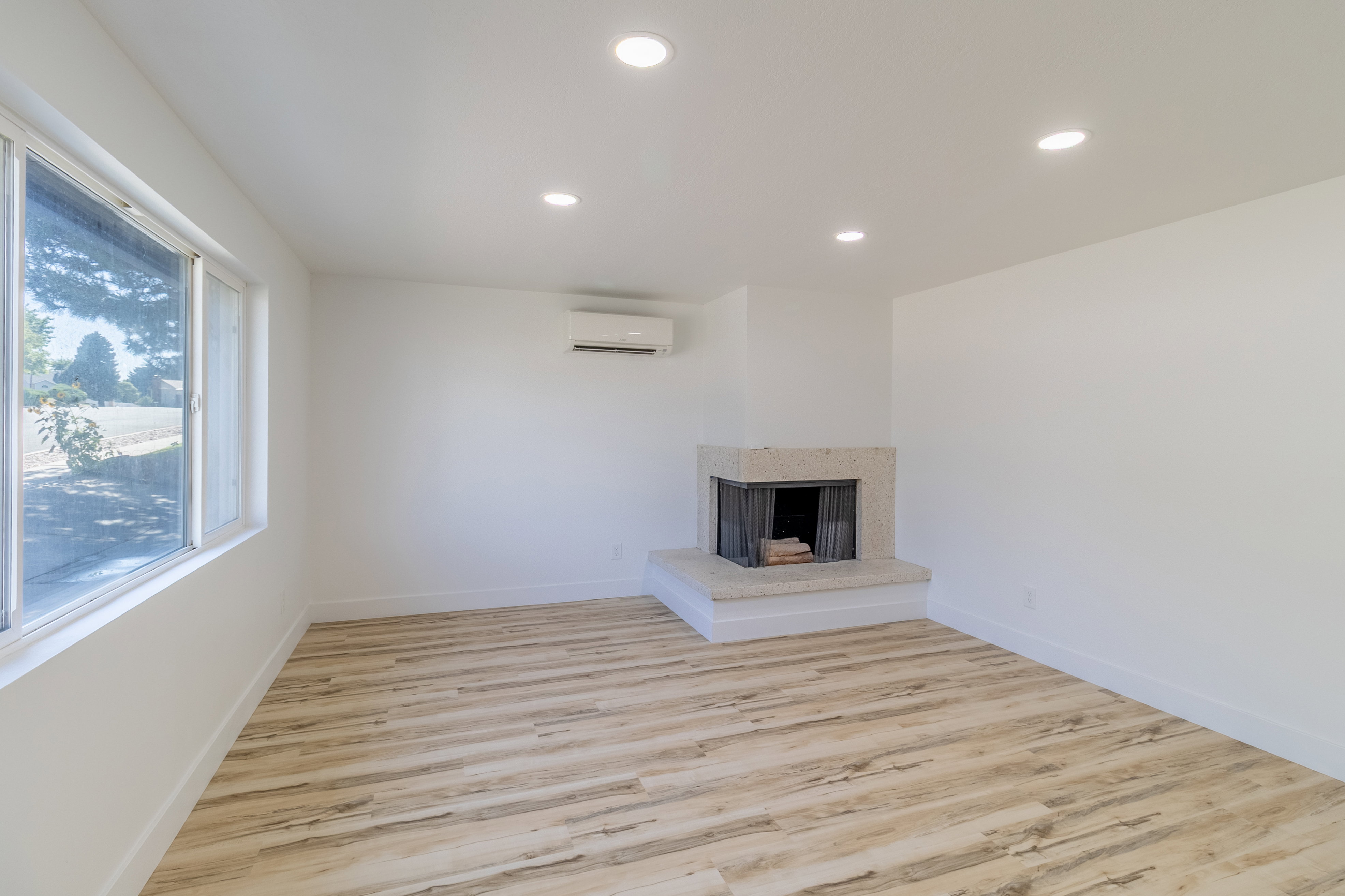 Light wood-finish flooring complements the white walls and recessed lighting