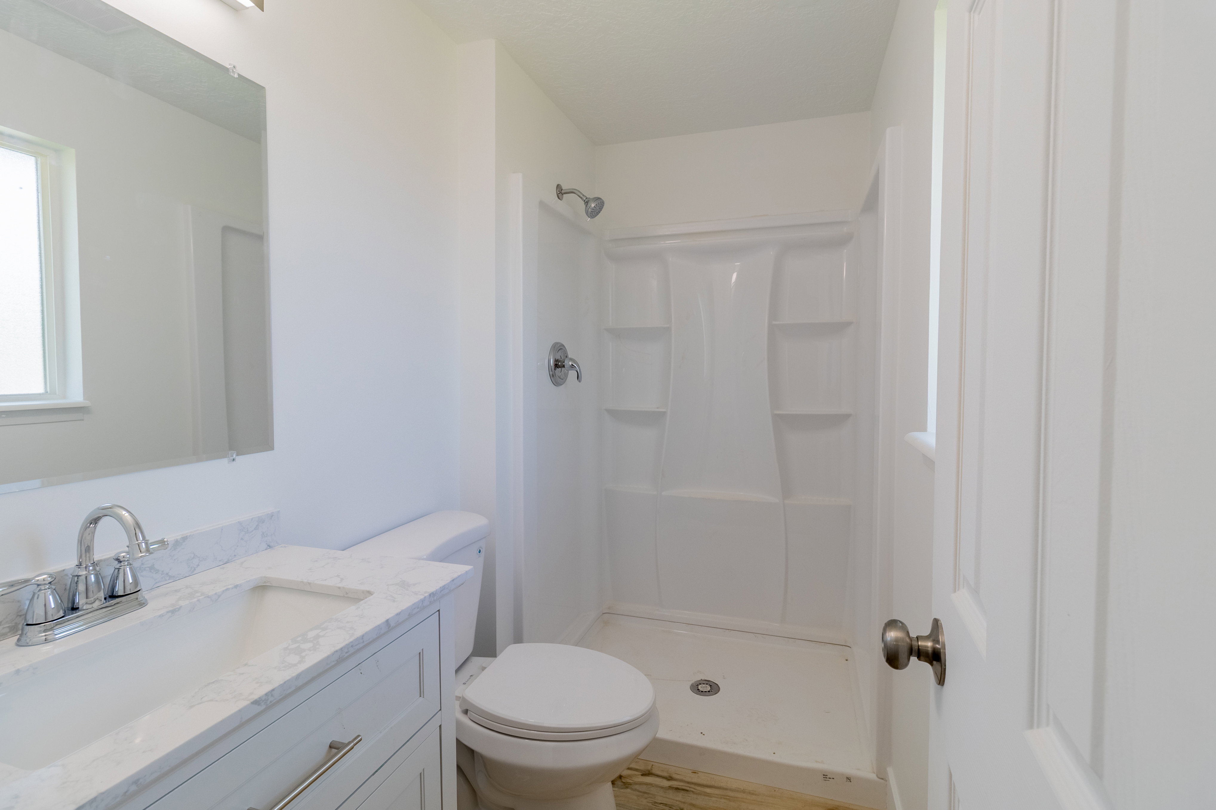 Bathroom featuring a white vanity with an integrated sink, polished chrome faucet, and a large wall mirror
