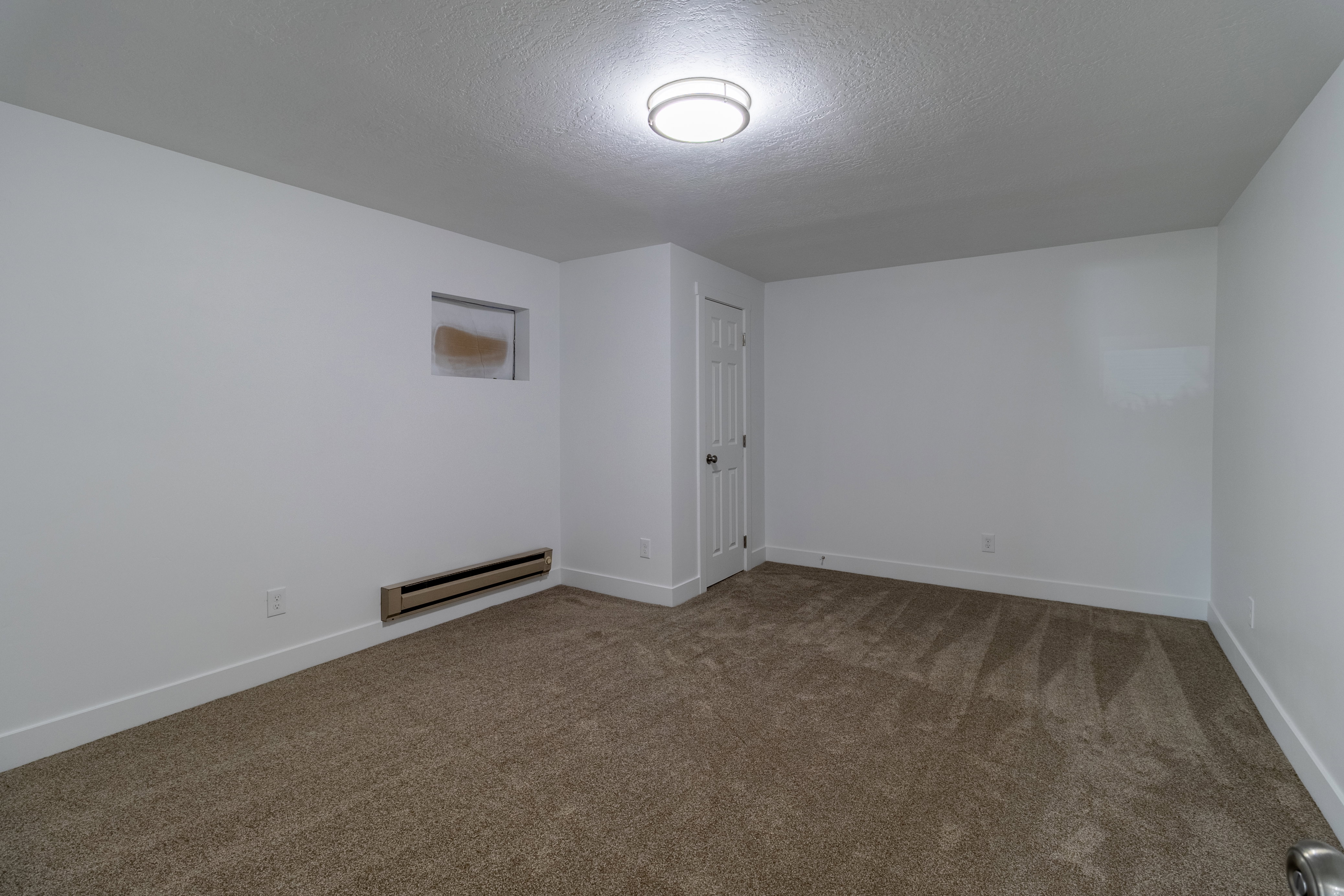 Neutral-toned carpet flooring with white baseboards throughout
