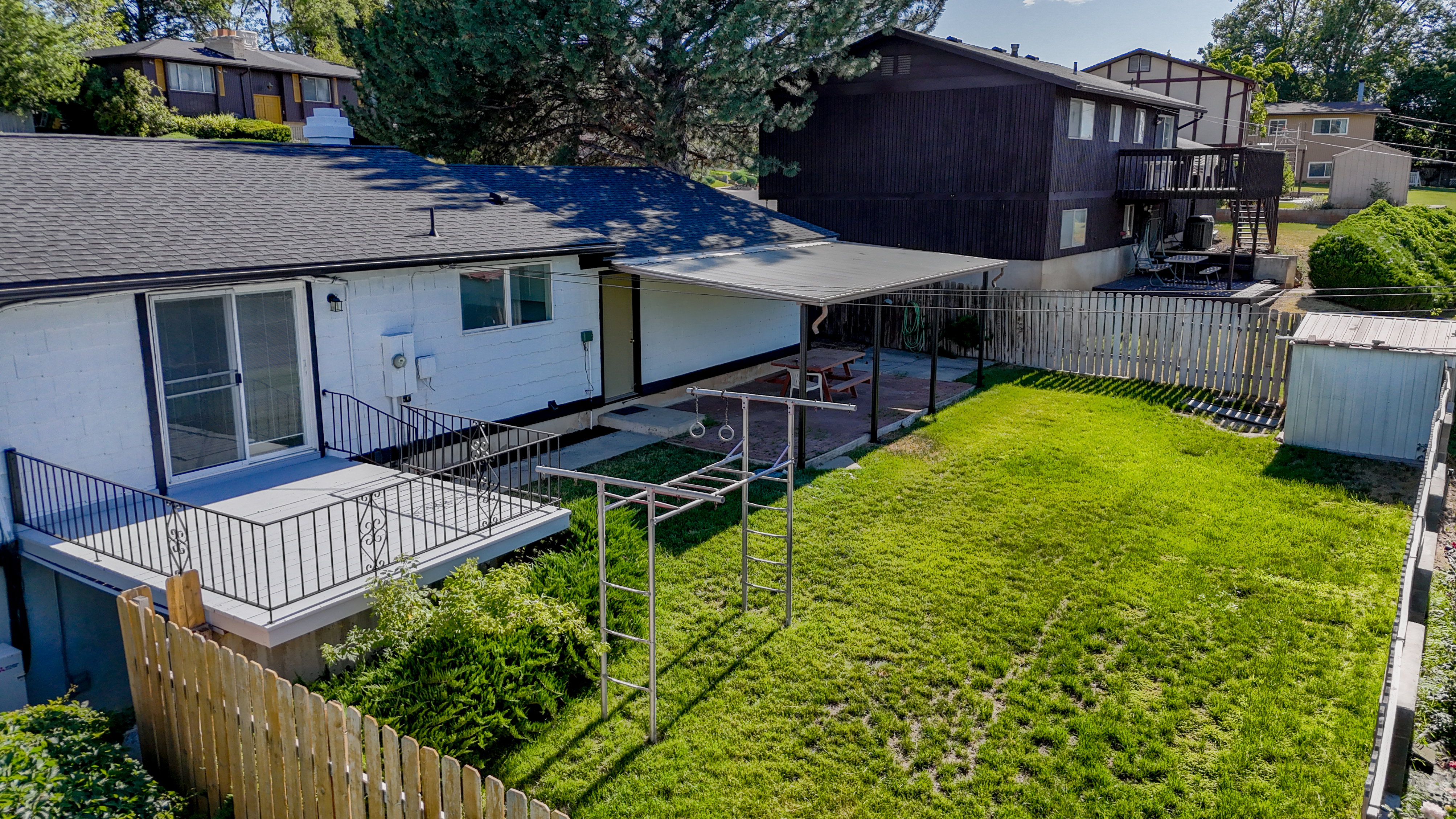 Expansive backyard featuring a fenced perimeter, a grass lawn, and mature landscaping