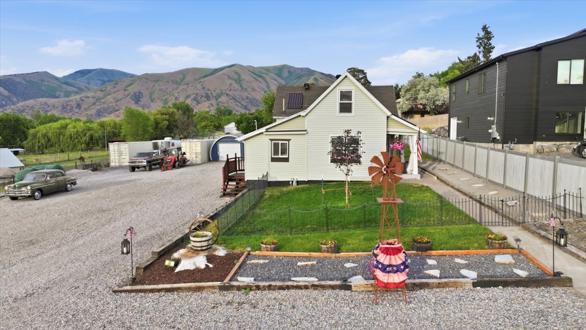 Well-maintained single-family home featuring a pitched roofline, solar panels, and light-colored siding