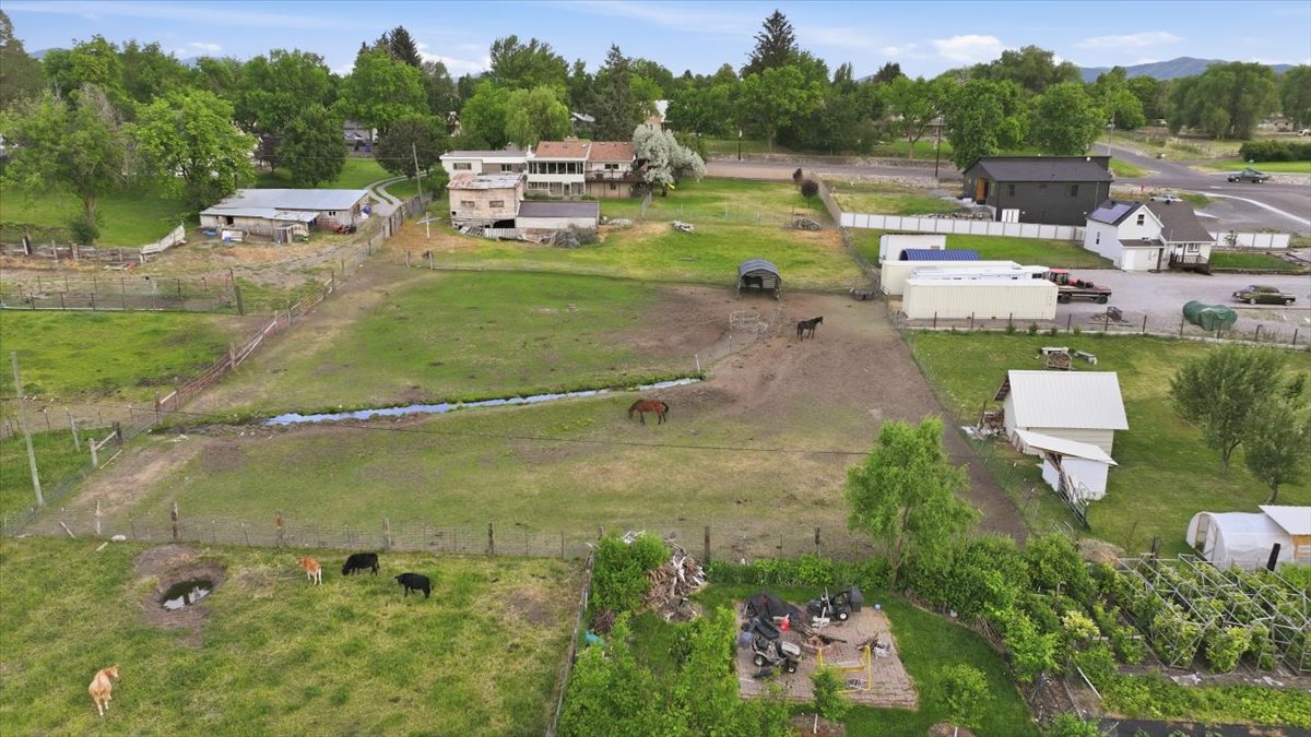 Expansive rural property featuring fenced pastures, multiple outbuildings, and a detached garage