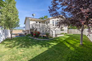 Expansive rear yard featuring a manicured lawn and mature trees