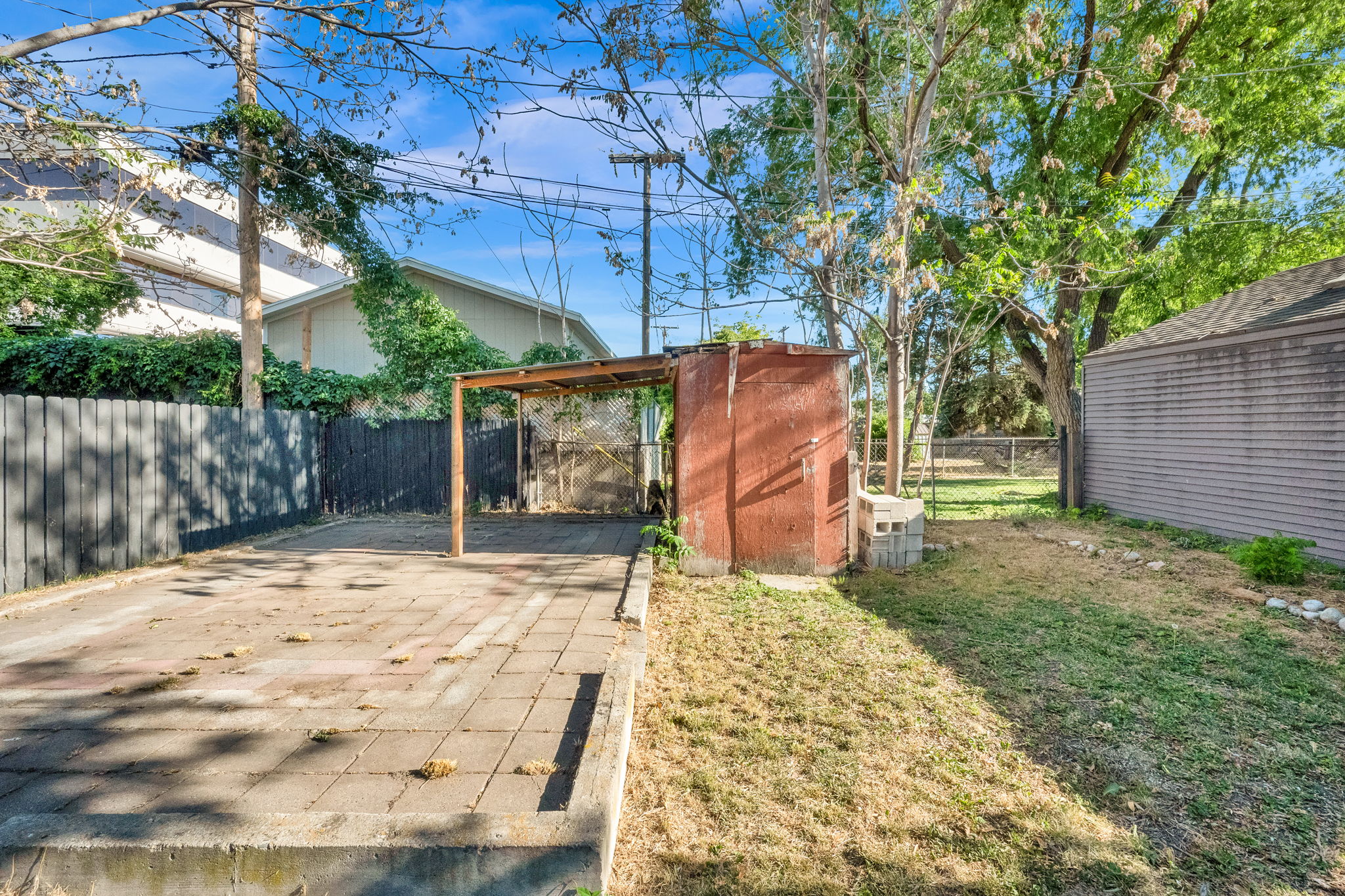Paved patio area featuring a metal-framed pergola