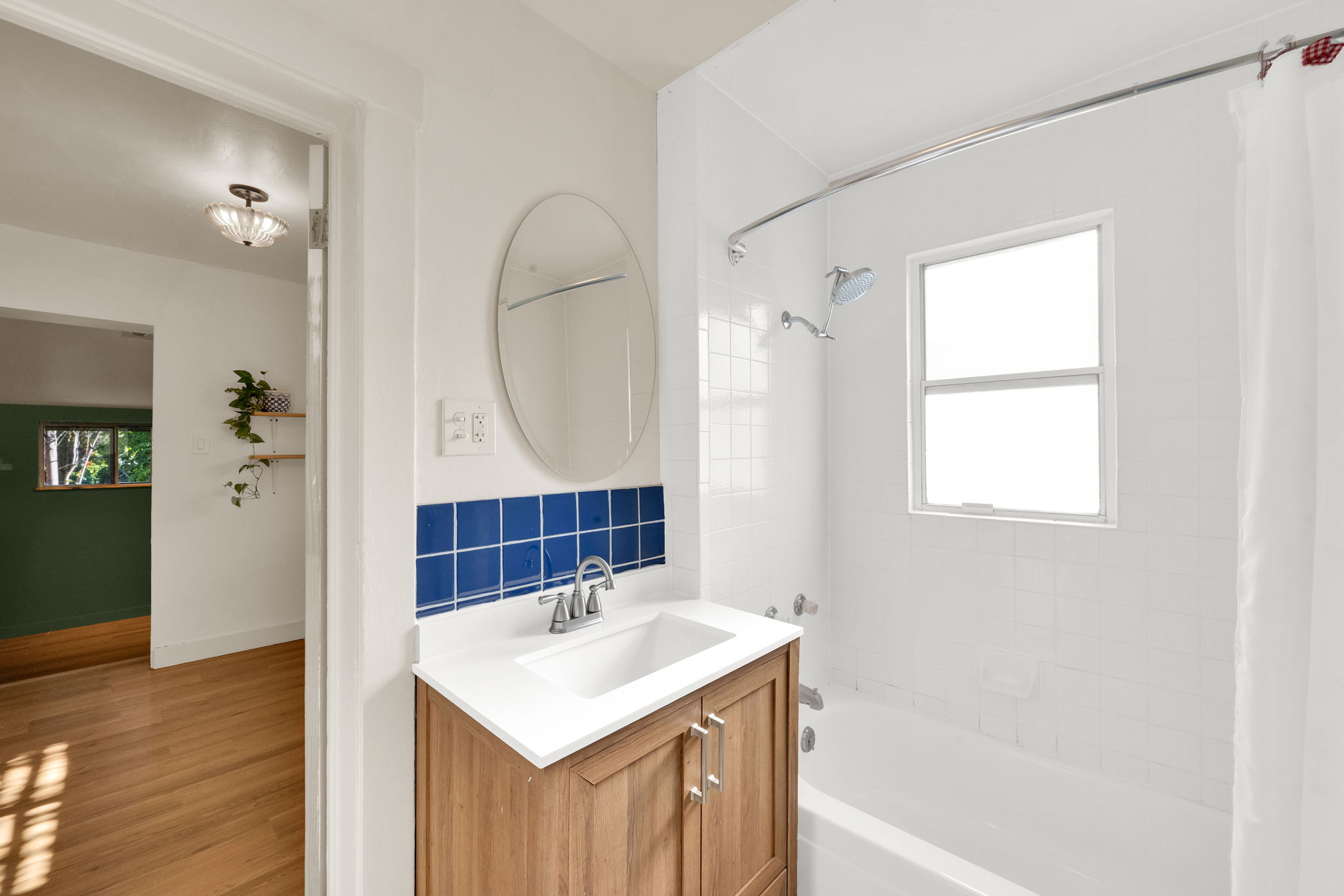 Bathroom featuring a light wood-finish vanity with a white countertop and integrated sink
