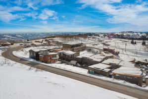Snowy aerial view with a residential view and a mountain view