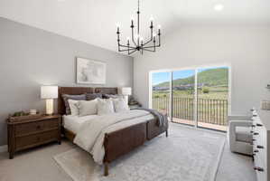 Vaulted bedroom featuring a black chandelier and sliding glass doors