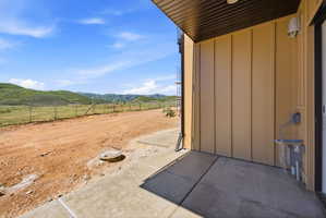 Exterior patio featuring concrete flooring and a brown overhang