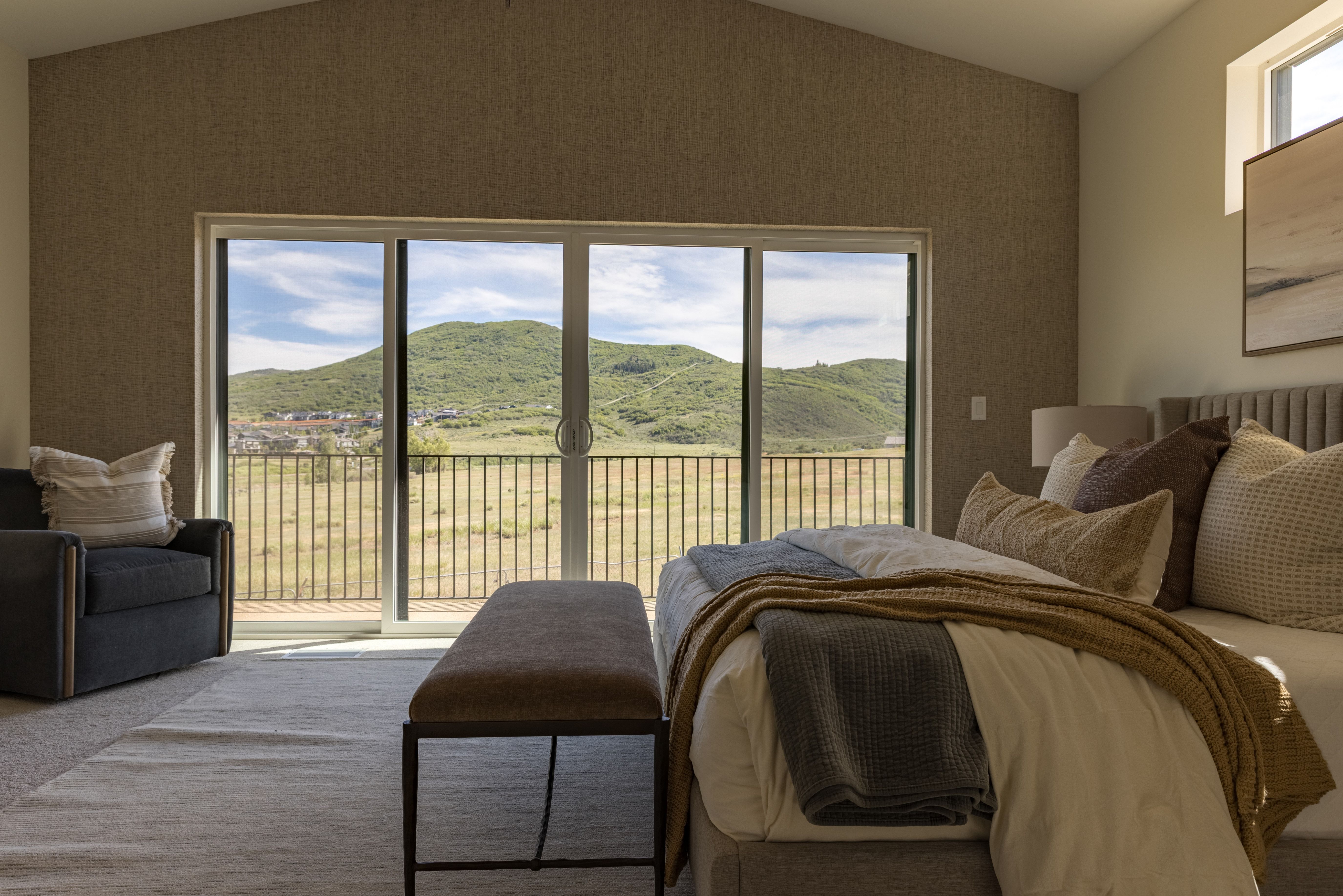 Vaulted ceilings above a full-width sliding glass door to a private balcony