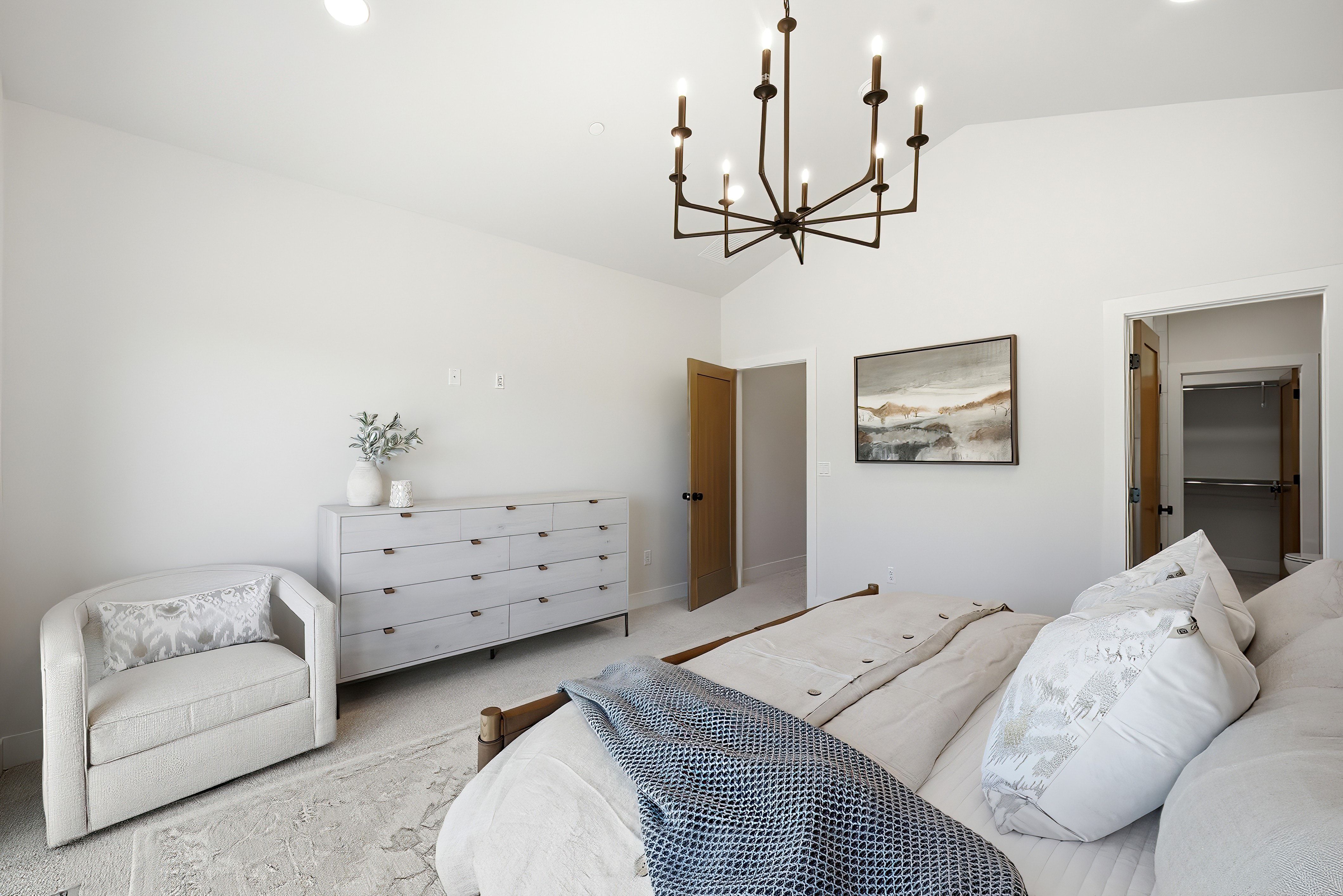 Vaulted ceiling featuring a contemporary chandelier, recessed lighting, and warm wood-finish interior doors