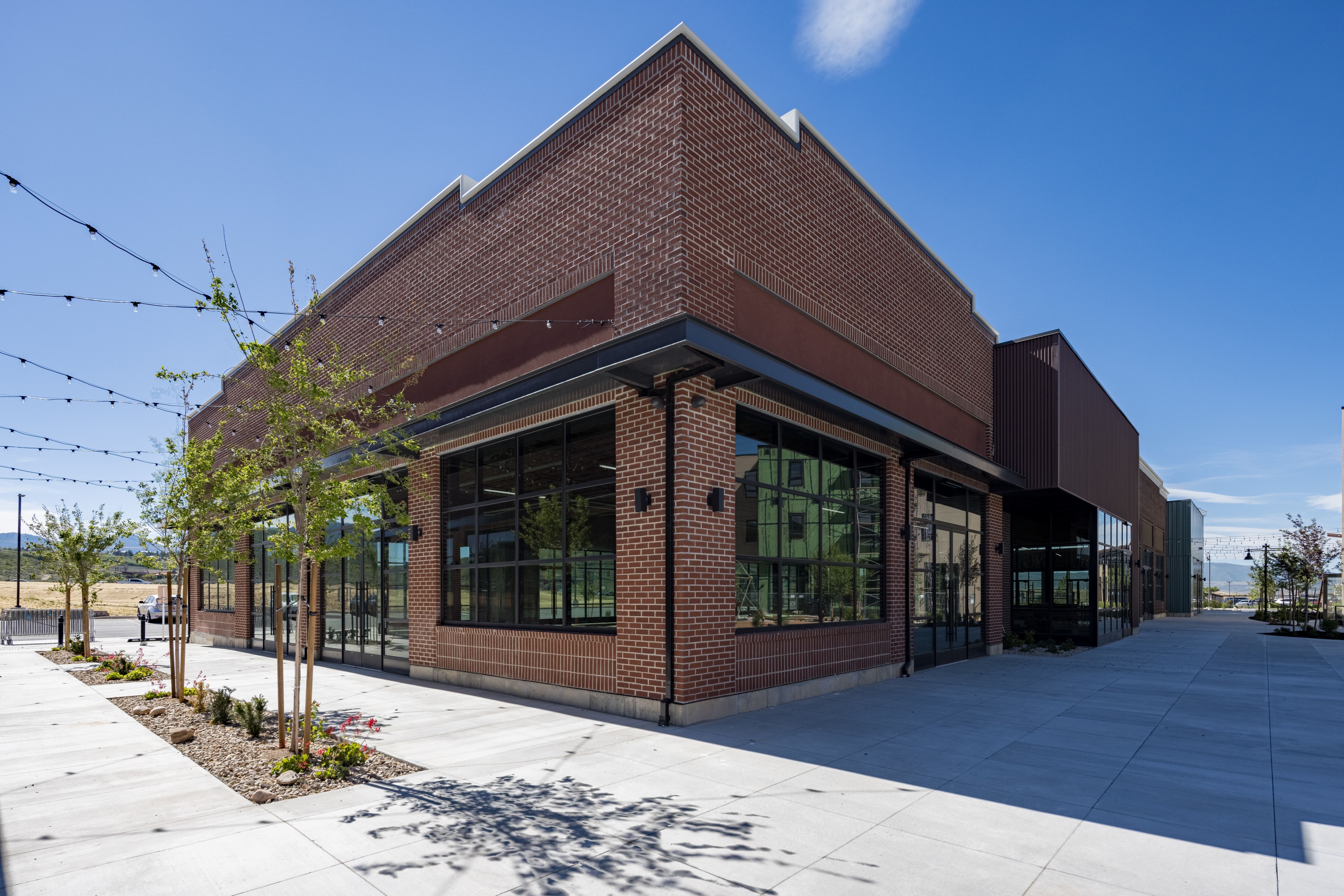 Contemporary commercial building featuring a brick facade with dark trim elements
