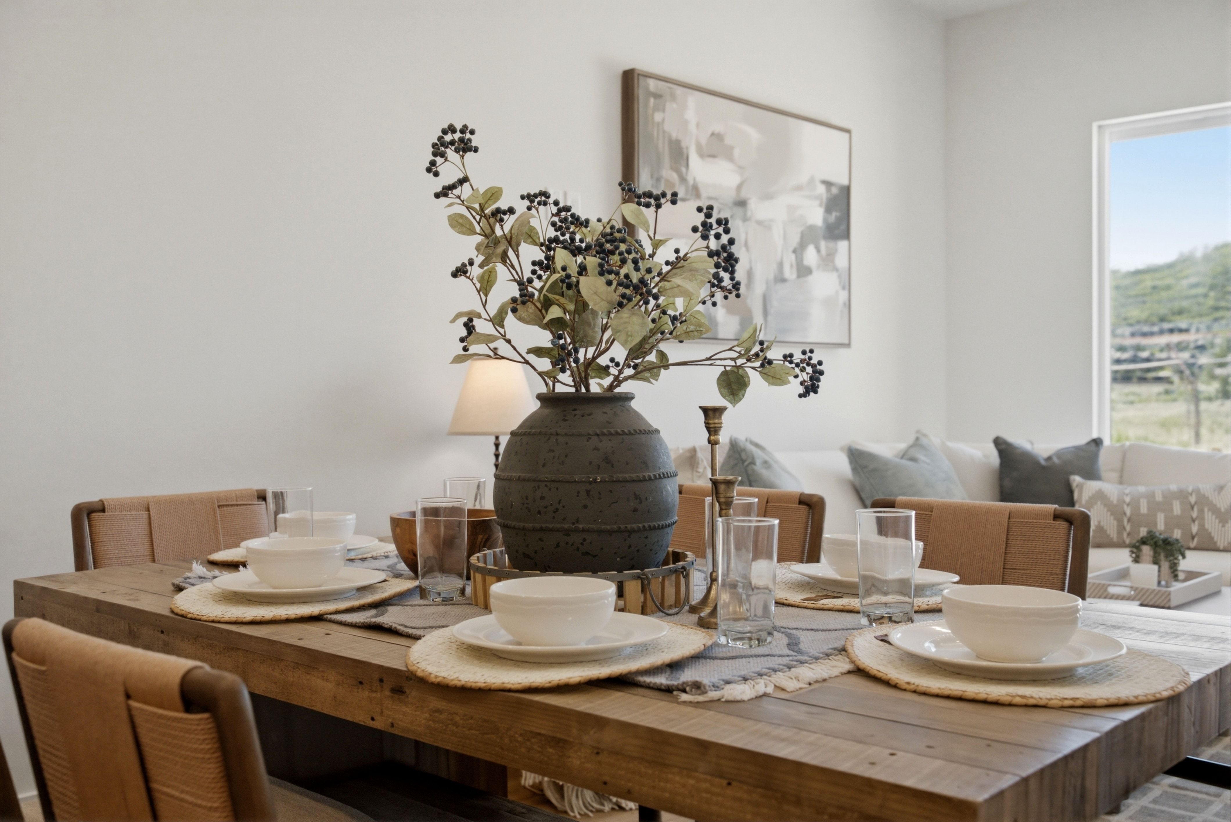Spacious dining area featuring a natural wood table, neutral wall tones, and a large window