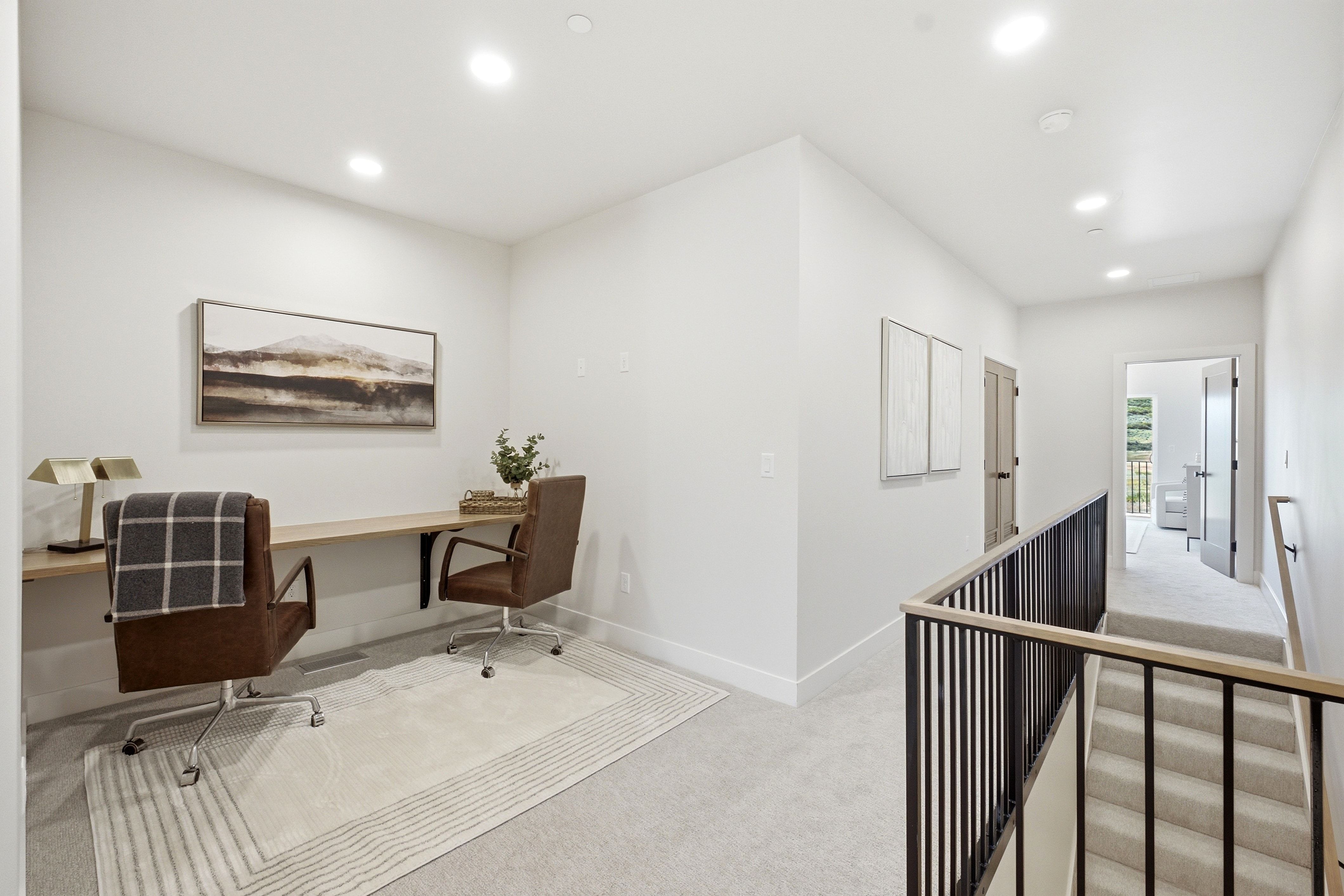 Upper-level landing featuring a built-in wood-finish desk, recessed lighting, and carpeted flooring