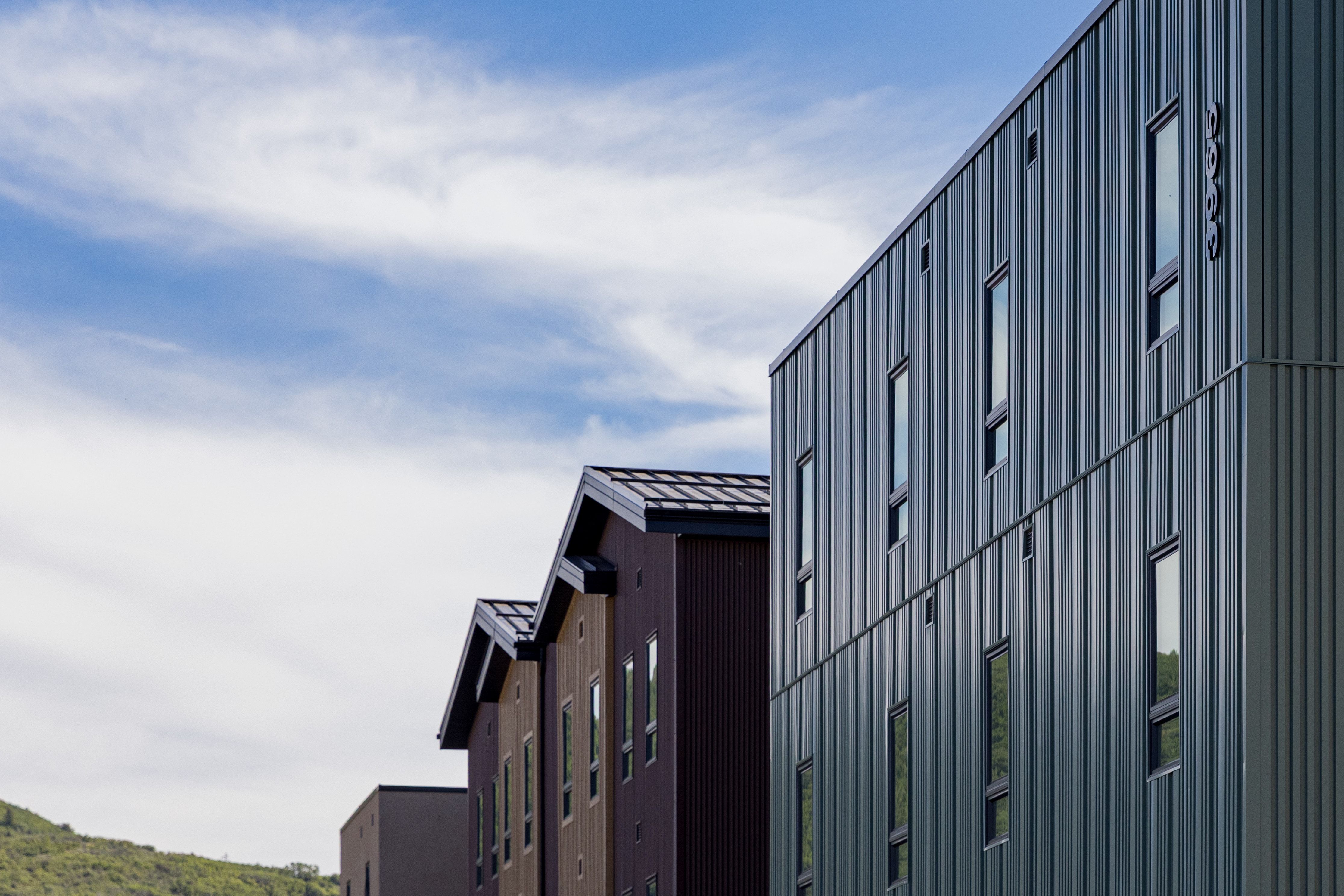 Contemporary vertical siding exterior with multiple vertical windows, a flat roofline, and visible building numbers