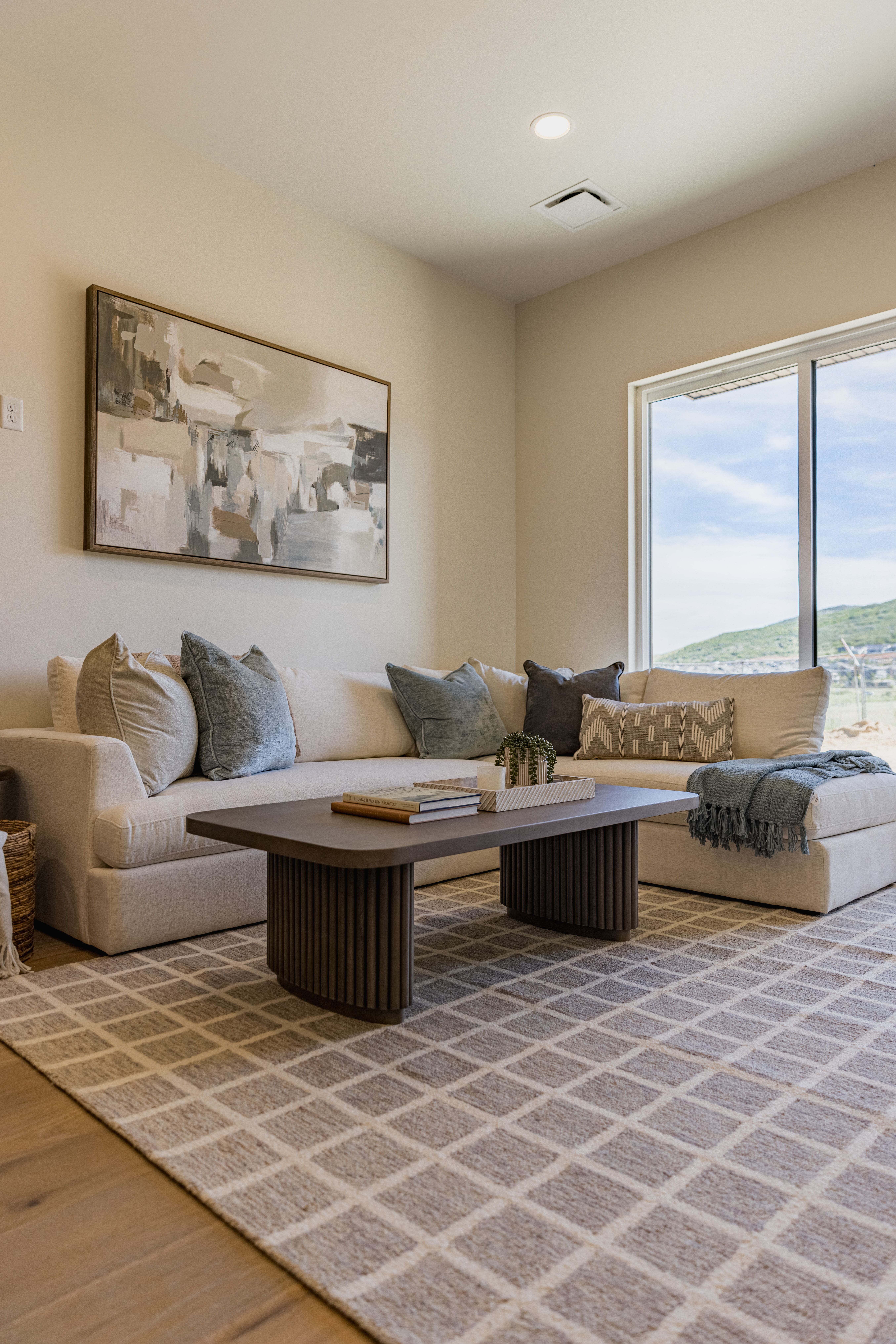 Inviting living area featuring light-toned walls, recessed lighting, and wood-finish flooring