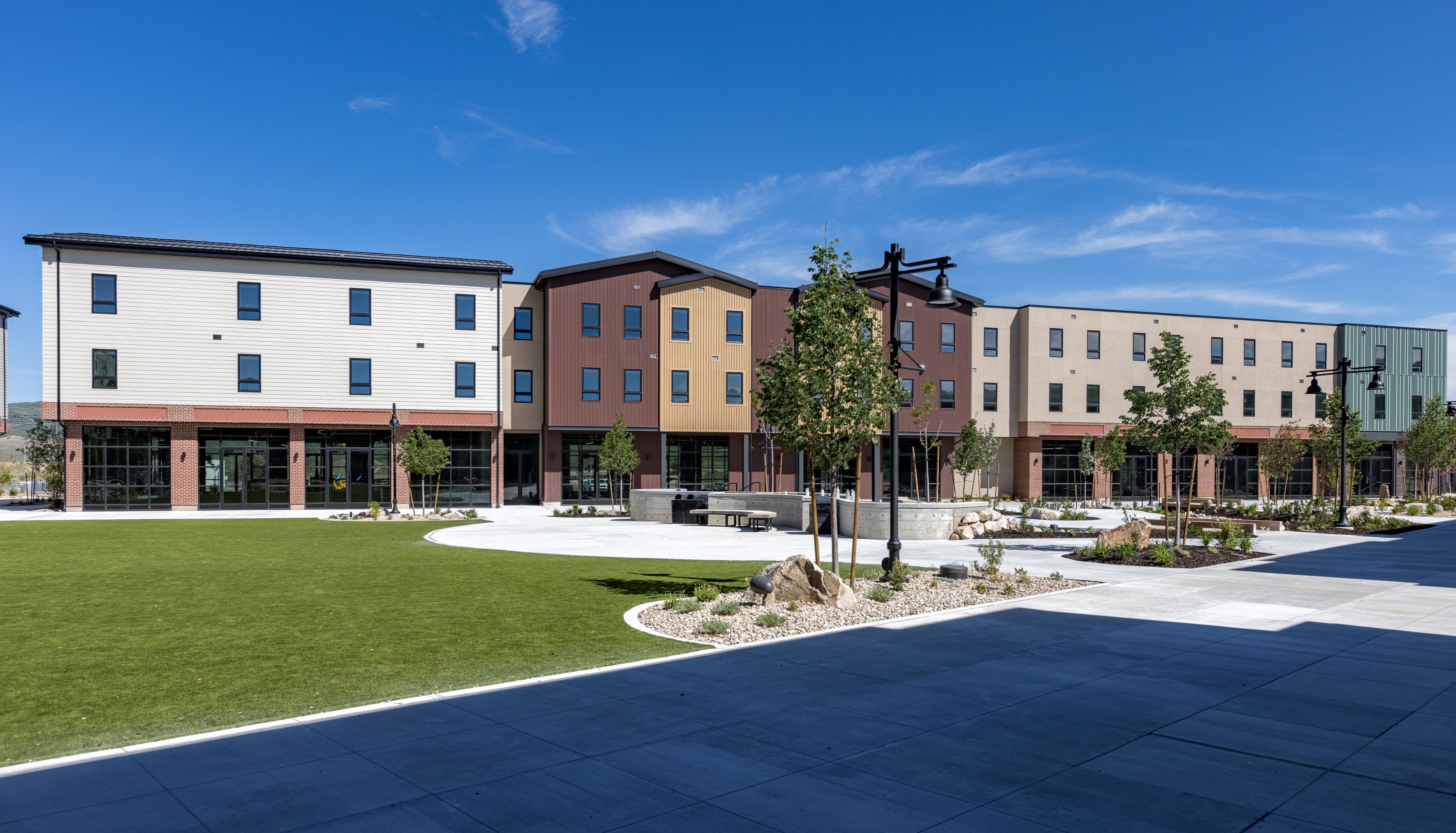 Contemporary multi-story buildings featuring varied facade paneling and ground-level glass storefronts