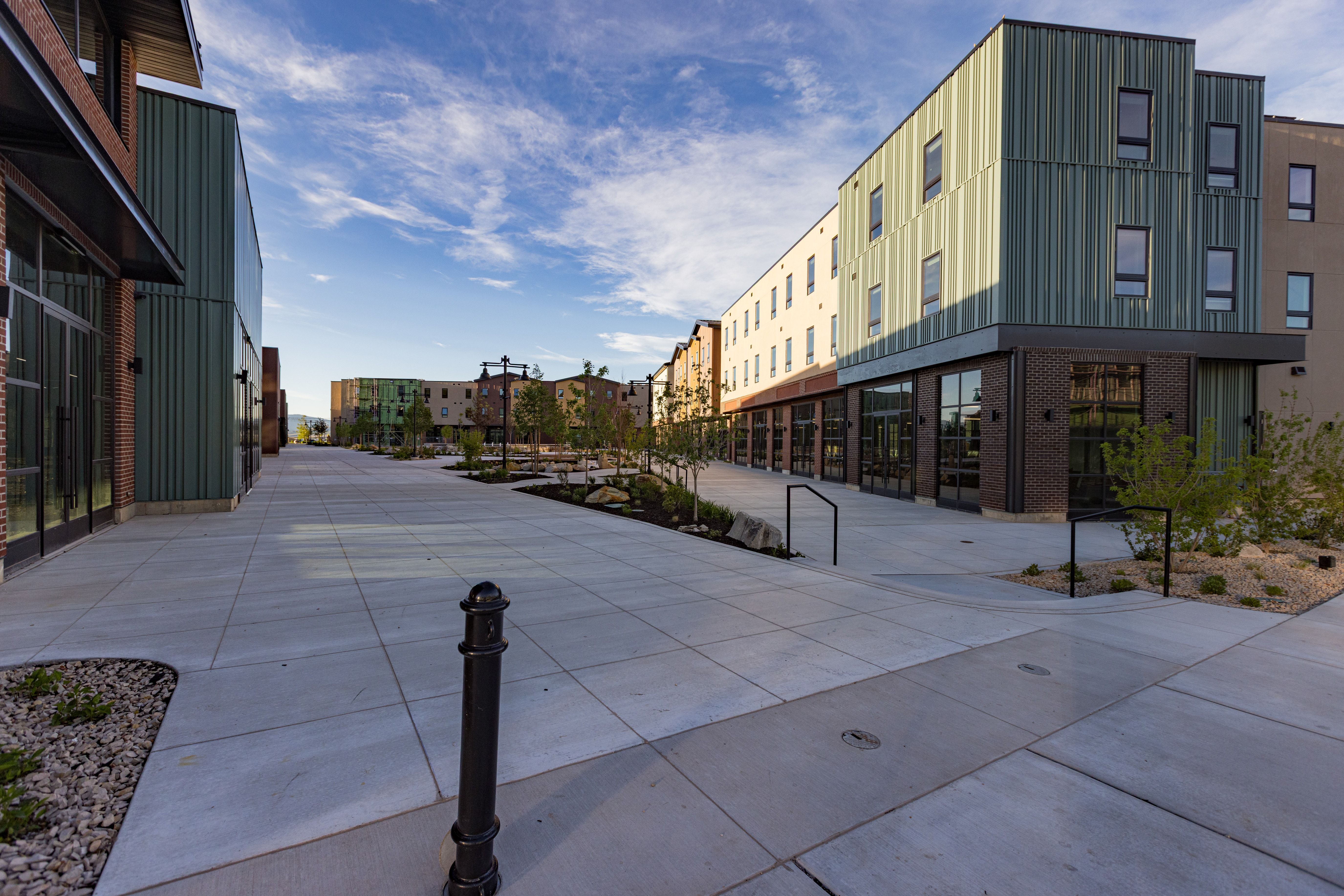 Modern multi-story buildings featuring varied architectural facades, including corrugated metal siding and brickwork