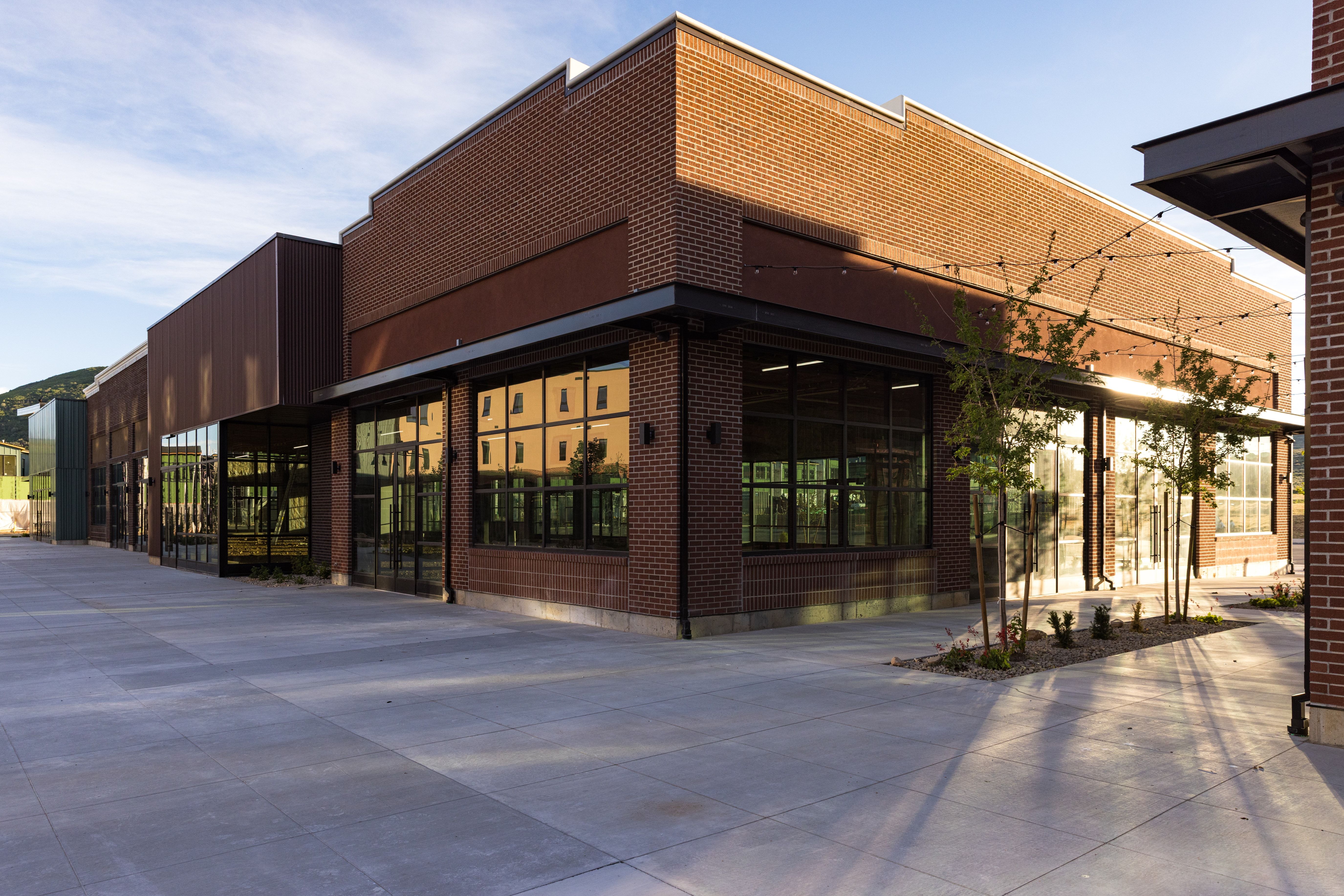 Contemporary commercial building featuring a brick facade and extensive glass storefronts
