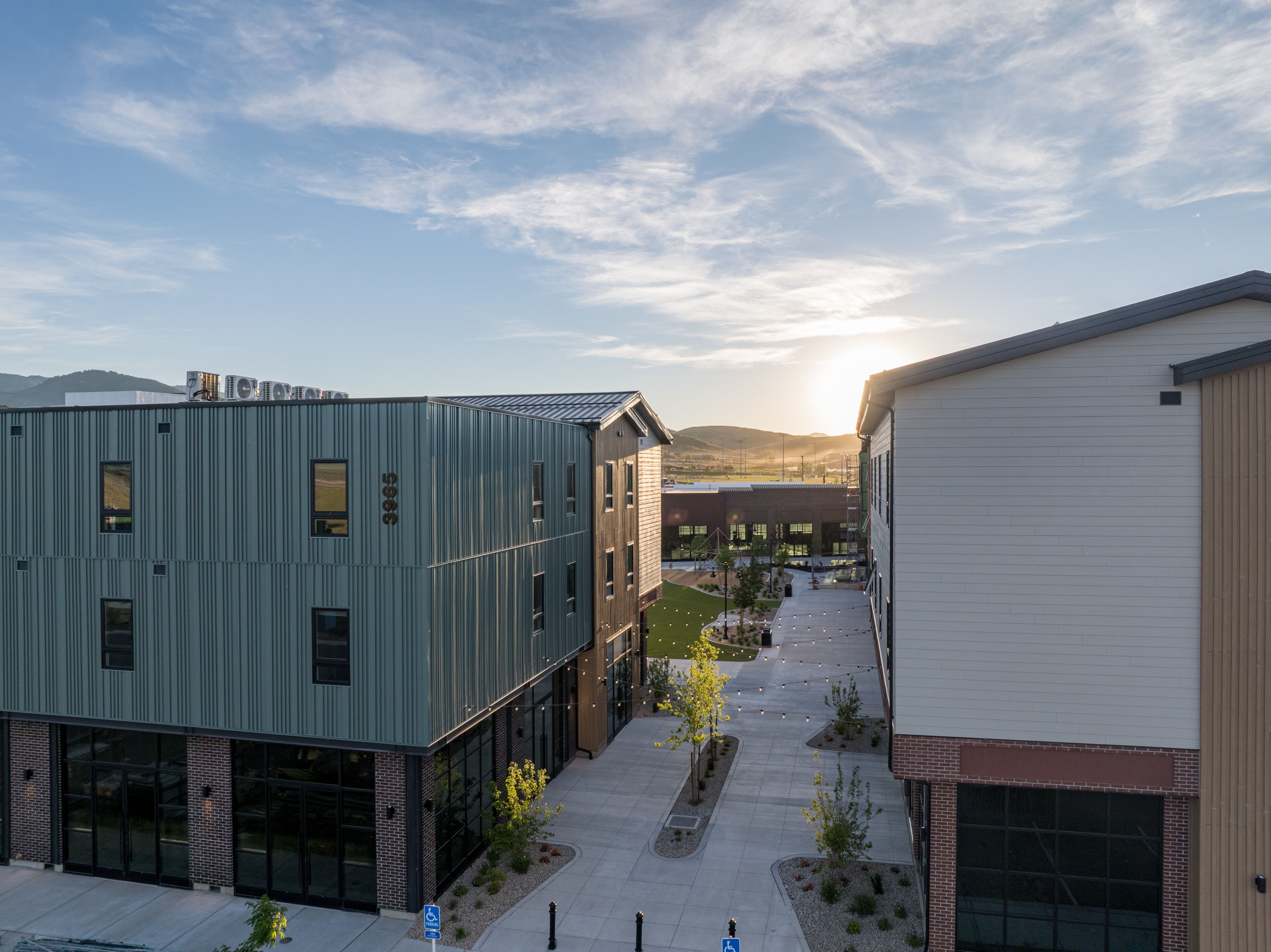 Modern building exteriors featuring corrugated metal siding, brick accents, and large storefront windows