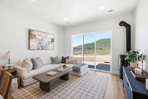 Spacious interior featuring a wood stove, light wood-finish flooring, recessed lighting, and expansive sliding glass doors