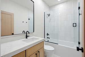 Bathroom featuring a single vanity with stone countertop, integrated sink, and matte black faucet