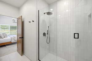 Glass-enclosed shower featuring vertical white subway tile, matte black fixtures, and a recessed shower niche