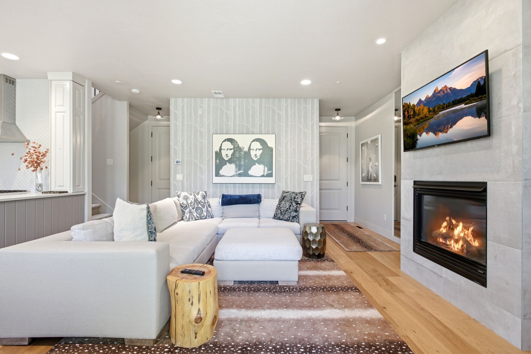 Living area featuring a fireplace with a stone surround, hardwood flooring, and recessed lighting