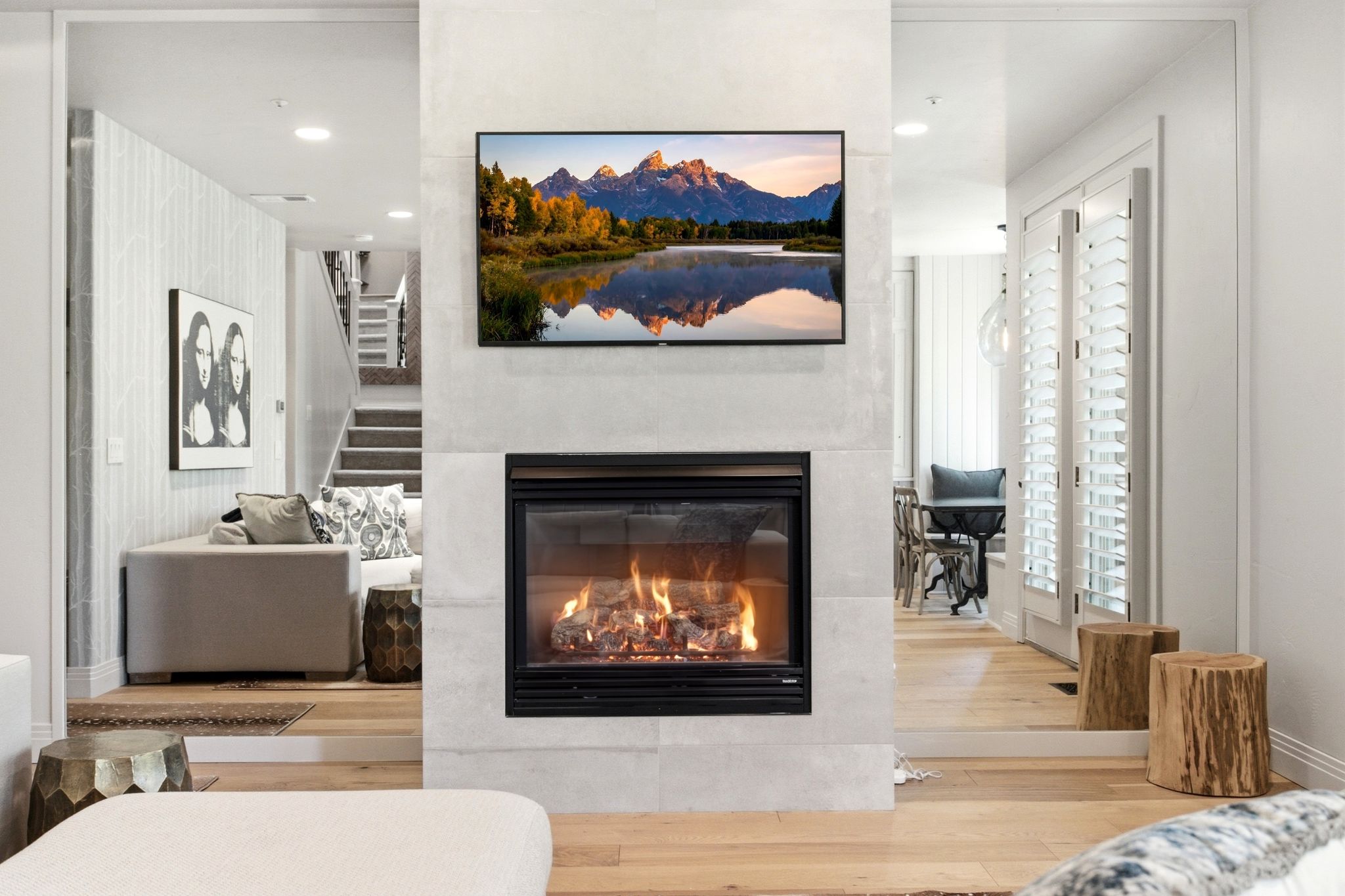 Central fireplace with a light-toned stone surround, integrated flat-screen, and a built-in firebox