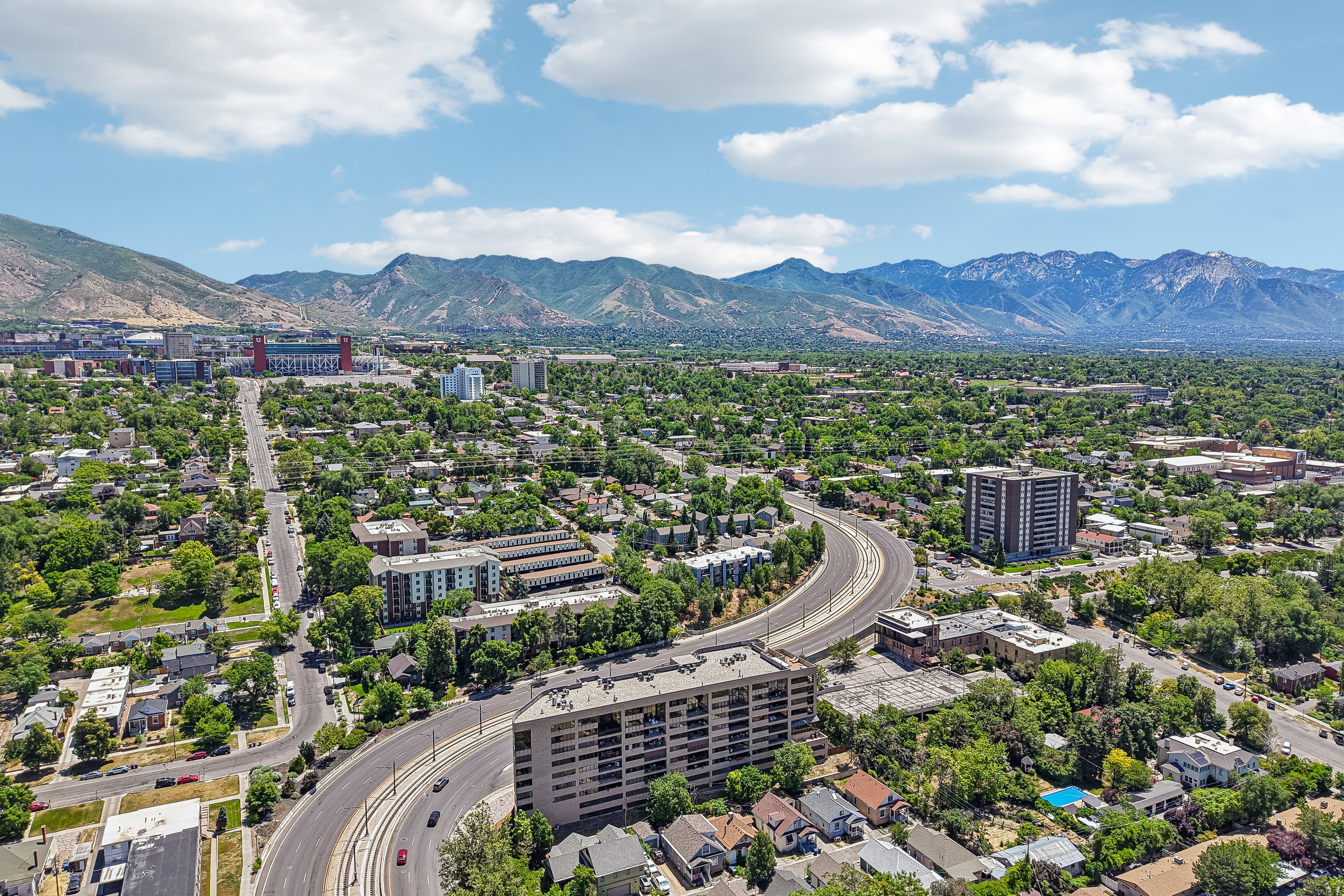 Expansive aerial perspective showcasing a verdant urban landscape with distant mountains