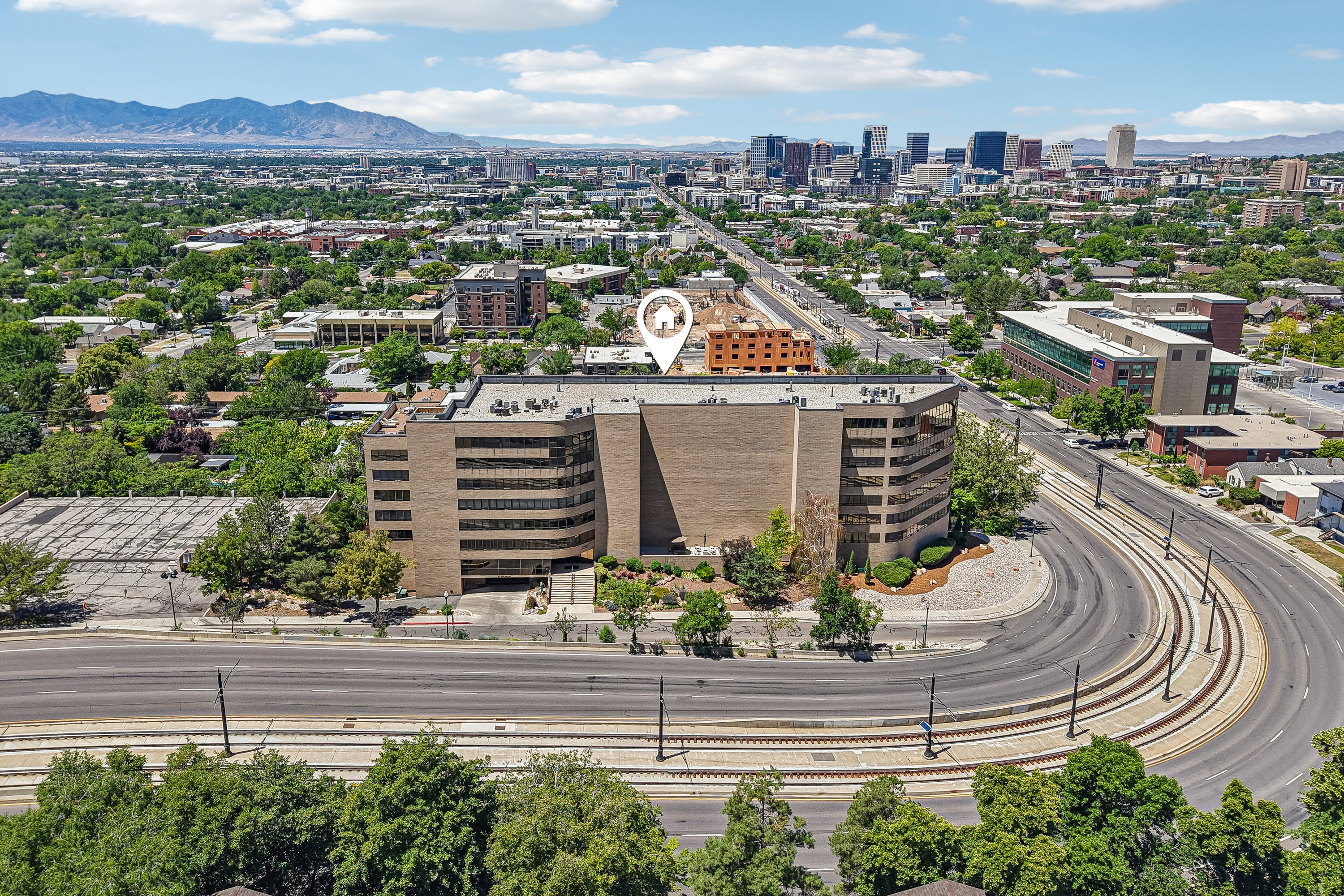 Aerial perspective showcasing a multi-story commercial building with a brick facade and numerous windows